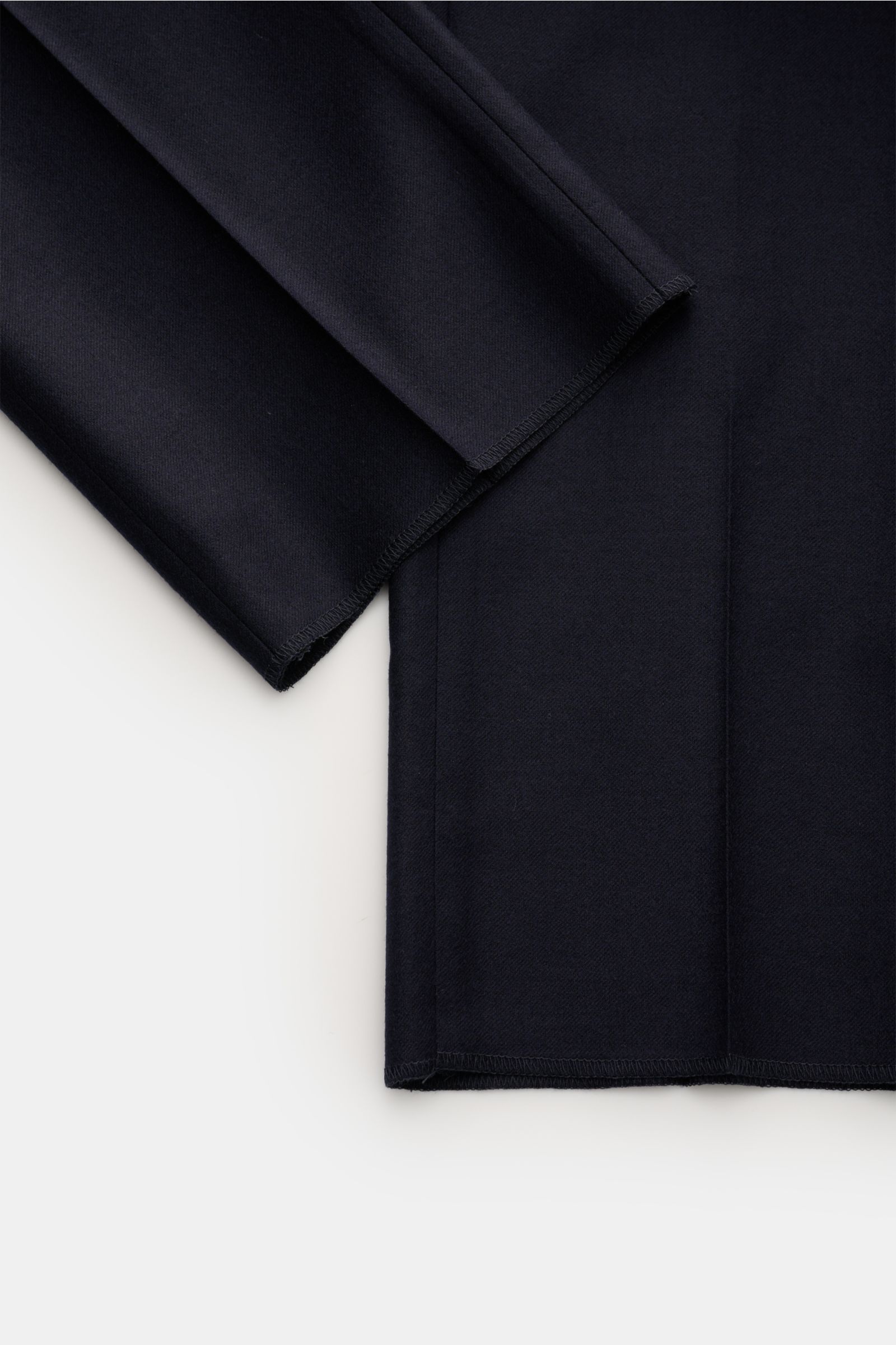 Close-up image of the open hem length of the navy GTA Wollhose 'Federico' showing pure wool fabric with a soft, slightly elastic, lightweight quality and a regular fit that tapers slightly, photographed from above. Features include zipper and waistband bu