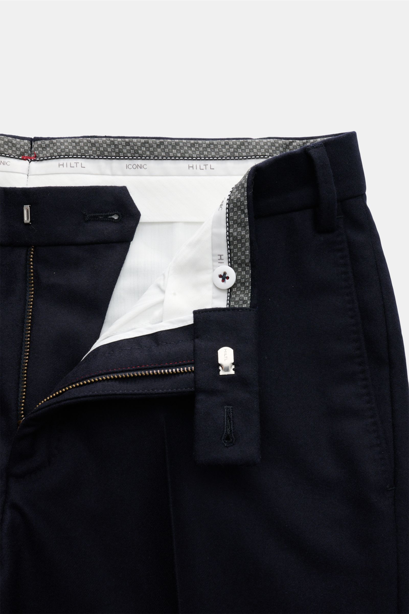 Close-up front view of Hiltl Wollhose 'Piacenza' dark navy wool trousers showing zipper, button, and waistband details.

Description: Office Essential: Die HILTL Hose 'Piacenza' vereint präzise Schneiderkunst mit modernem Komfort und wird so zum unverz