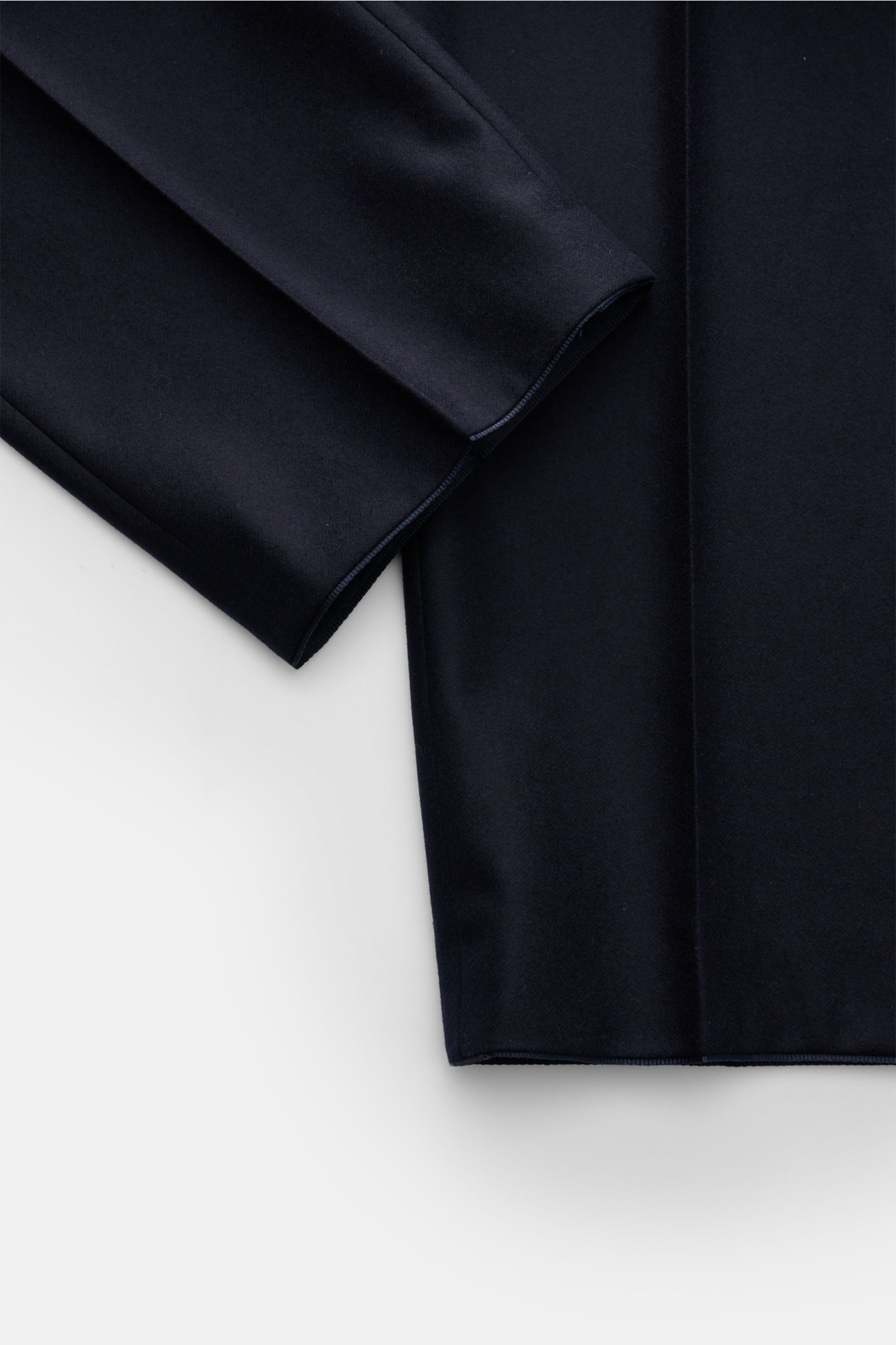 Close-up top-down view of the hem and lower leg of the Hiltl Wollhose 'Piacenza' dark navy, showcasing its smooth twill wool fabric and clean stitching. 

Office Essential: Die HILTL Hose 'Piacenza' vereint präzise Schneiderkunst mit modernem Komfort u