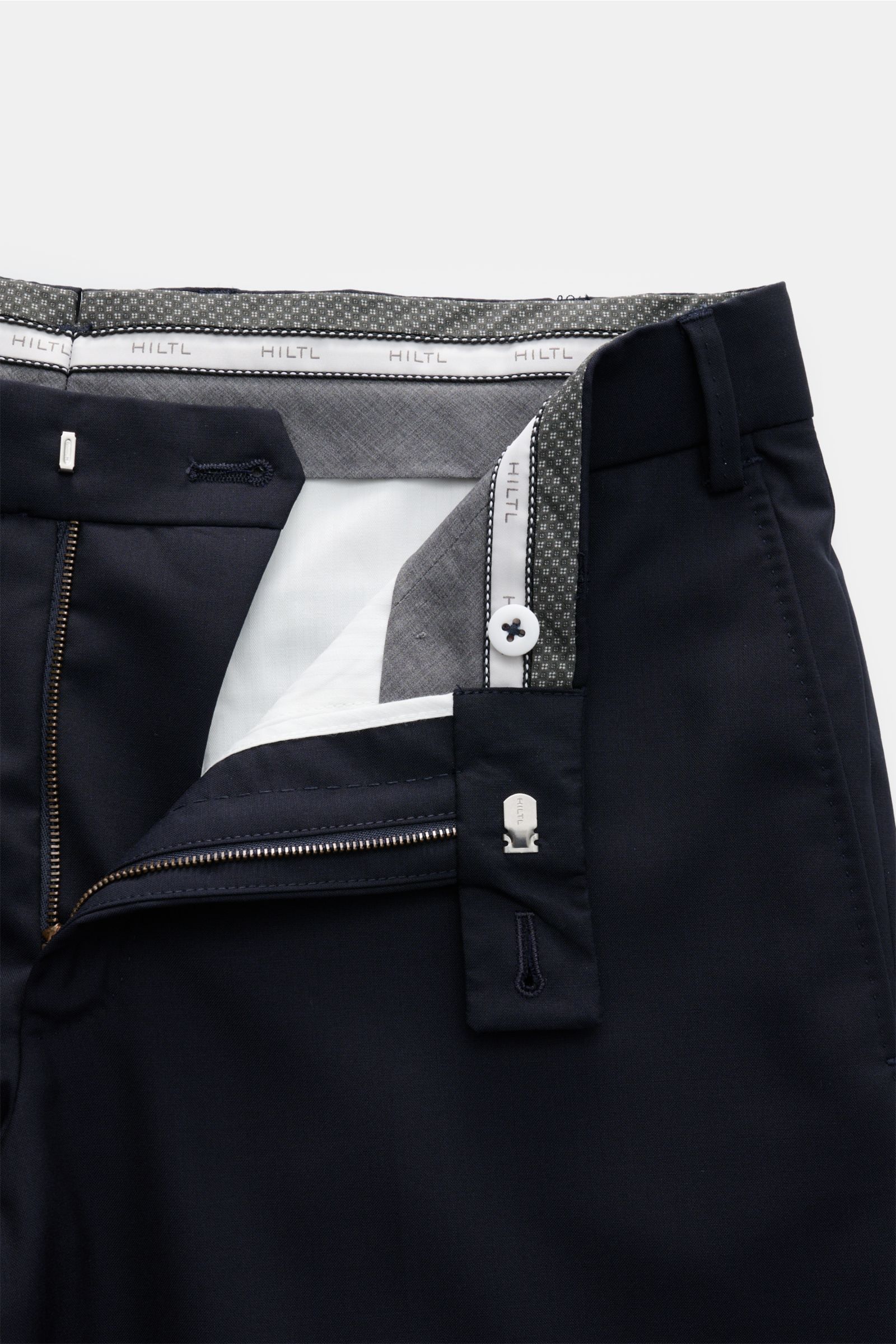 Hiltl Wollhose 'Piacenza' dark navy, Twill aus reiner Wolle, Regular Fit, gerader Schnitt, Reißverschluss, Bundknopf, französische Taschen, Gesäßtaschen mit Knopf, glatter Griff, offene Länge, Detailansicht von oben.