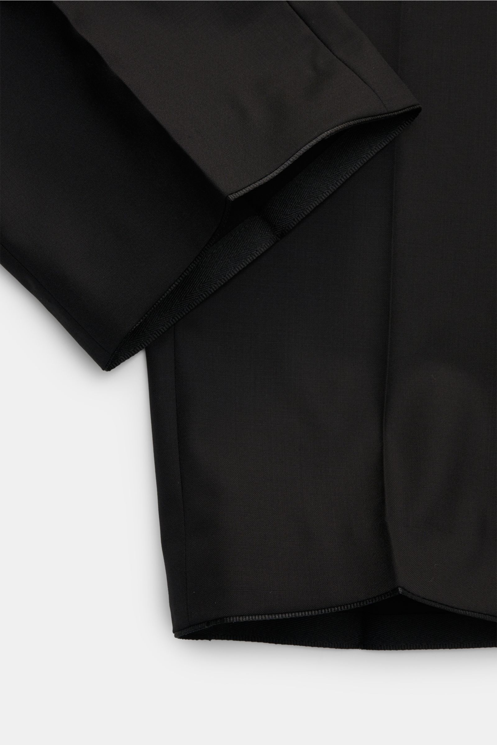 Hiltl Wollhose 'Piacenza' schwarz, Detailaufnahme von offenem Saum in Twill aus reiner Wolle, Regular Fit, glatter Griff, Reißverschluss, Bundknopf, französische Taschen, Gesäßtaschen mit Knopf, gerader Schnitt, feine Qualität.