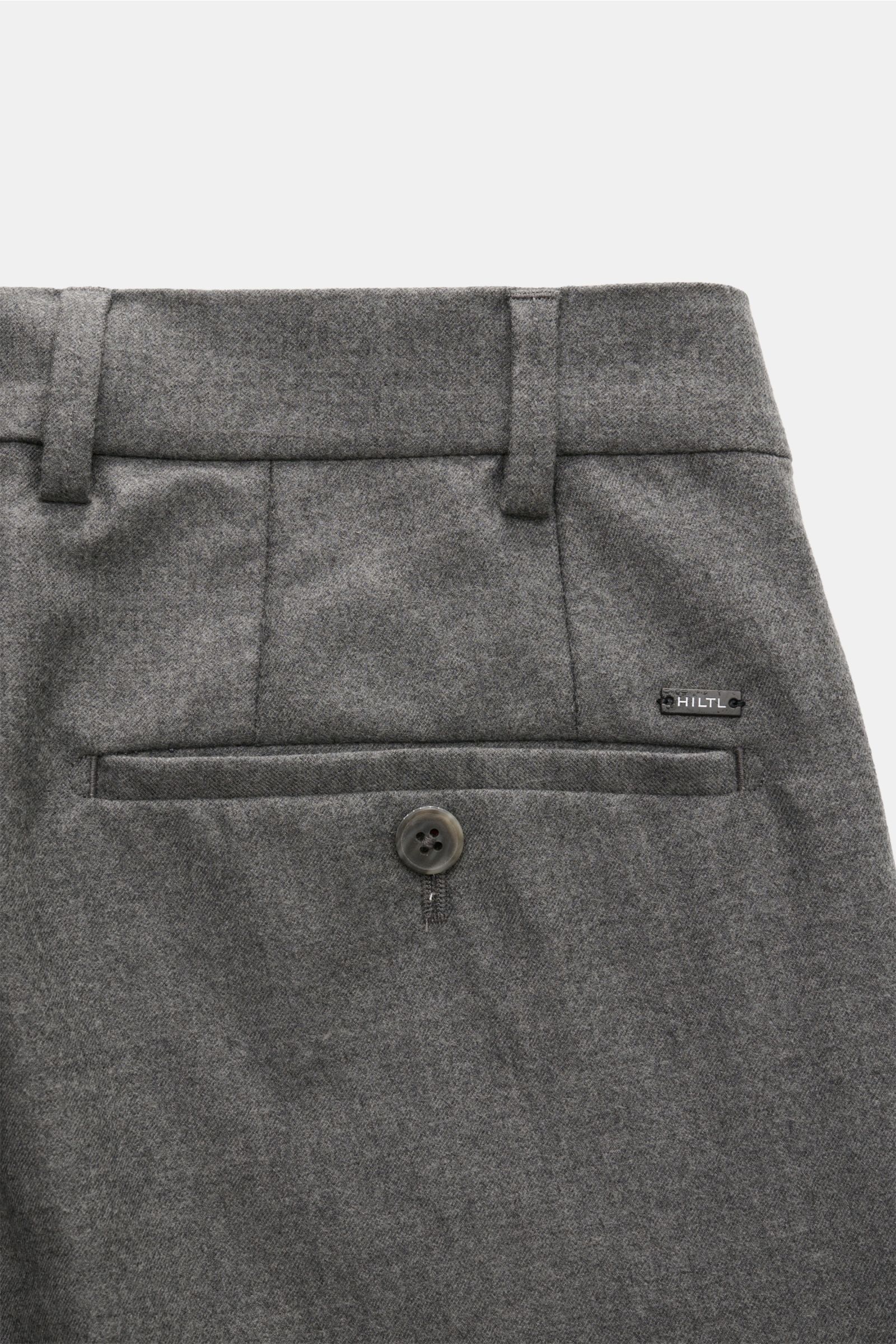 Close-up rear view of Hiltl Wollhose 'Piacenza' grau meliert, showcasing buttoned back pocket, belt loops, and fine wool-cashmere twill fabric.

Office Essential: Die HILTL Hose 'Piacenza' vereint präzise Schneiderkunst mit modernem Komfort und wird so