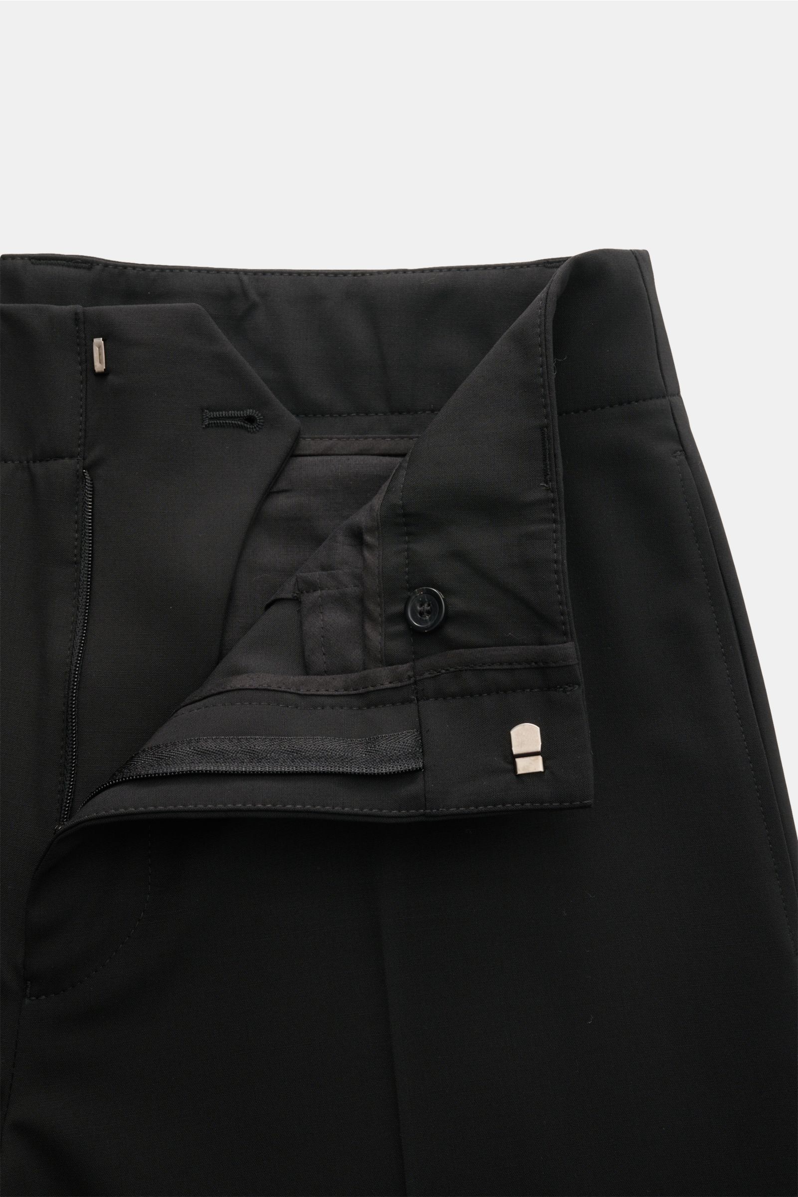 Close-up front view of Emporio Armani Wool trousers black showing elastic virgin wool fabric, zip and hook fastener, soft feel, regular fit, straight short cut, side seam pockets, jetted back pockets, and open length. Office essential: These wool trousers