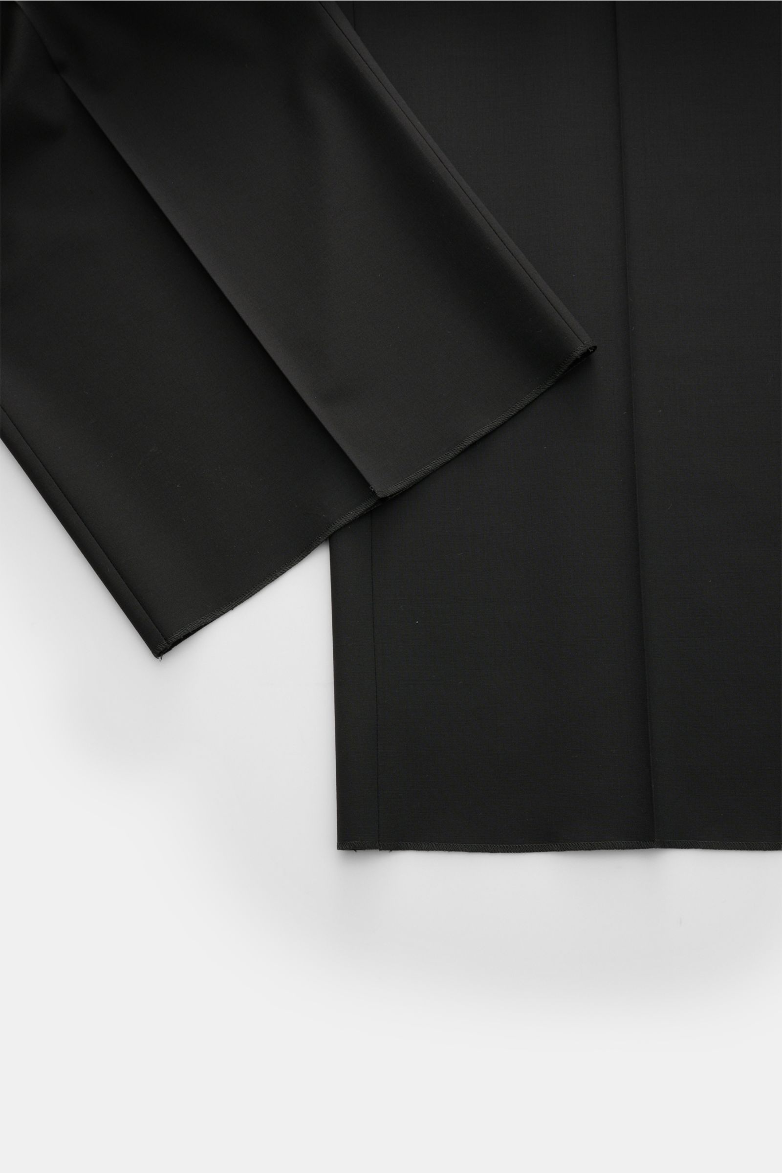 Close-up, top-down view of Emporio Armani Wool trousers black showing the straight, short cut hem and smooth elastic virgin wool fabric, highlighting the soft feel and regular fit. Office essential: These wool trousers by EMPORIO ARMANI are comfortable, l