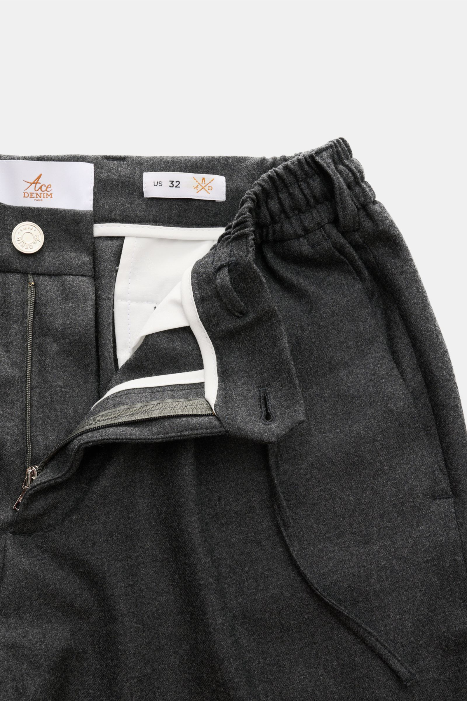 Close-up front view of Ace Denim Wool jogger pants dark grey melange showing zip, waist buttons, partially elasticated waistband with drawstring, made of virgin wool twill with slightly elasticated fabric, very soft feel, regular fit, slightly tapered cut
