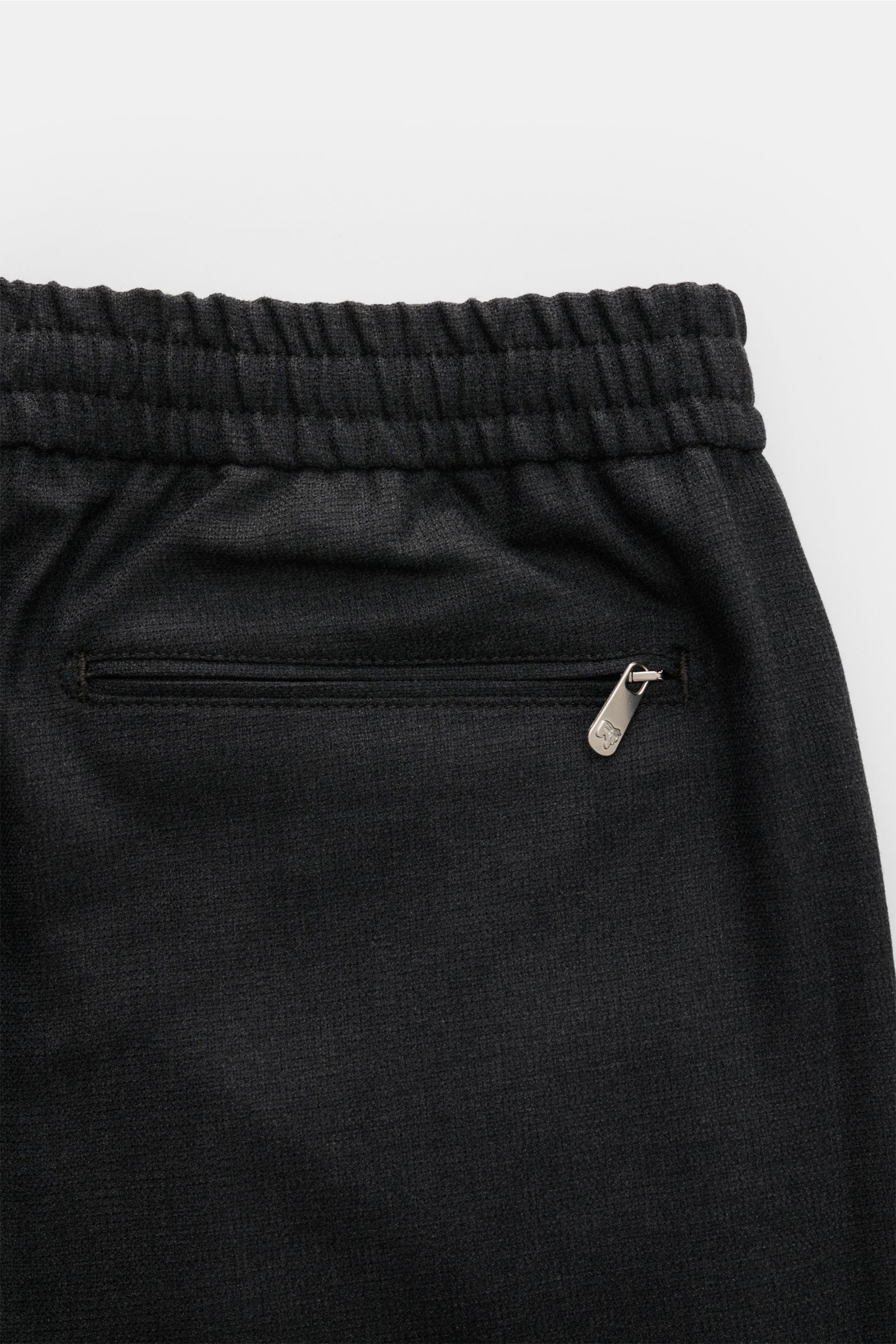Close-up rear view of Marco Pescarolo Woll-Jogpants 'Caracciolo' anthrazit showing elastic waistband and zippered back pocket in dark wool fabric.

Description: Die elegante Jogpants 'Caracciolo' vom italienischen Modelabel MARCO PESCAROLO vereint edle