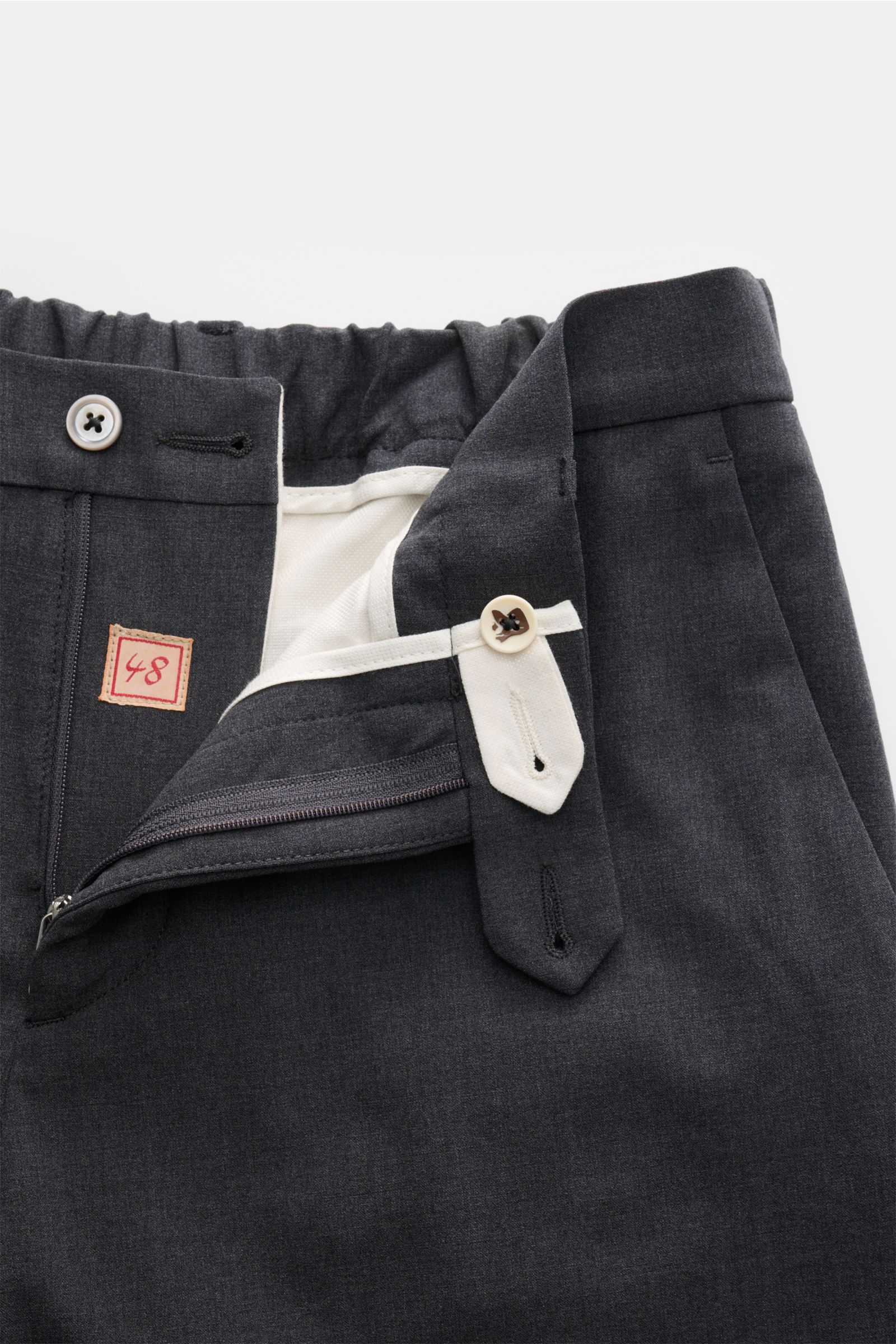 Close-up front view of the Marco Pescarolo Wollhose 'Evo' dunkelgrau meliert showing the elastic wool fabric, soft texture, partly elastic waistband, zipper, button closure, and tailored details. Exquisite Fertigung und Materialqualität sind kennzeichn