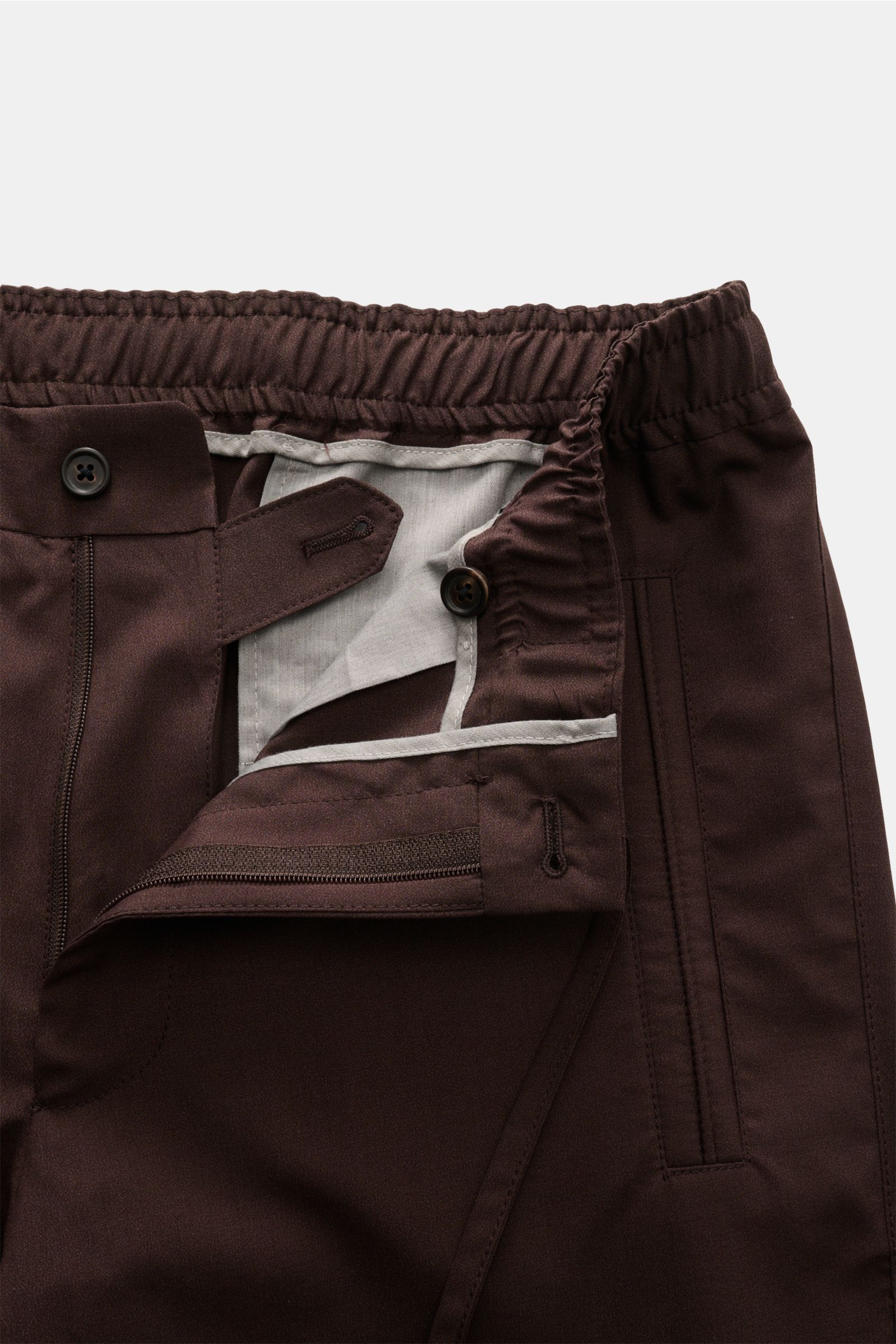 Corneliani Jogpants dunkelbraun close-up from the front showing elastic waistband, button, zipper, and pocket details in luxurious wool-silk blend fabric. Smart casual with luxury factor: Jogpants by CORNELIANI impress with fine virgin wool-silk mix and m