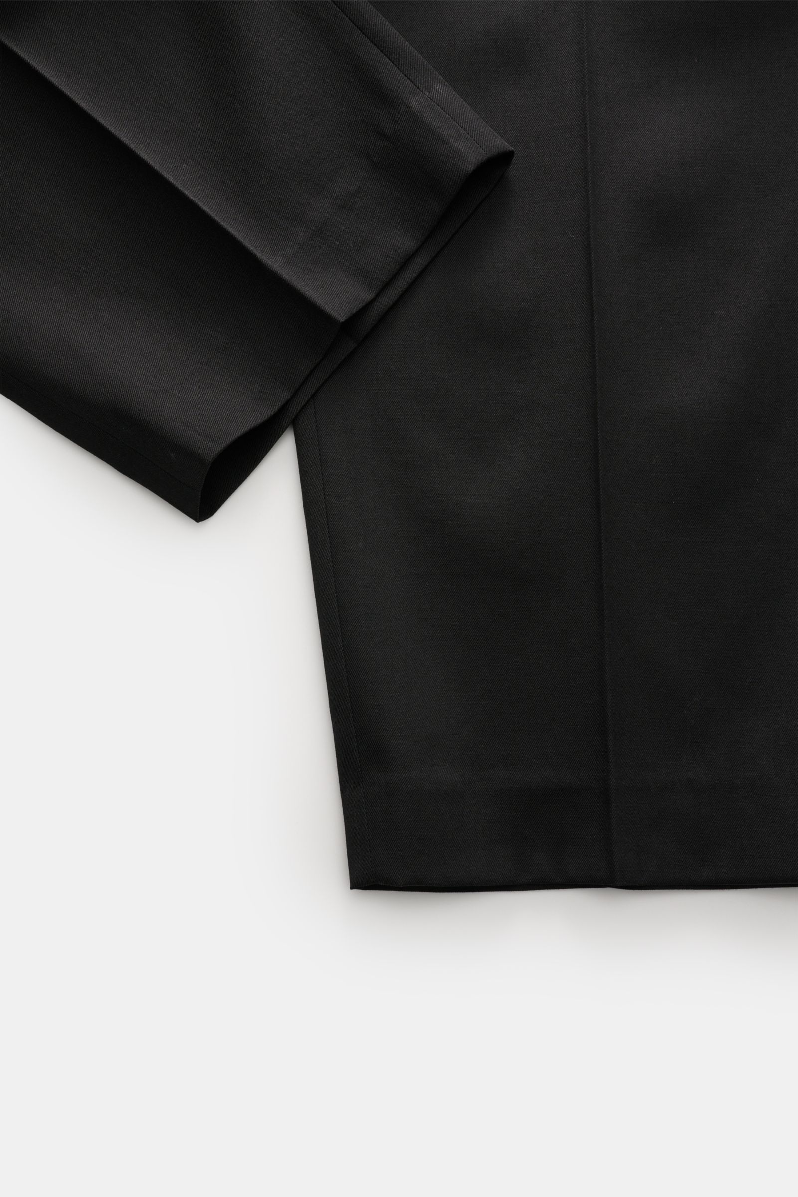Close-up angled view of Golden Goose Wool trousers black, showcasing timeless elegance with tapered fit, double pleat, and robust virgin wool twill fabric.