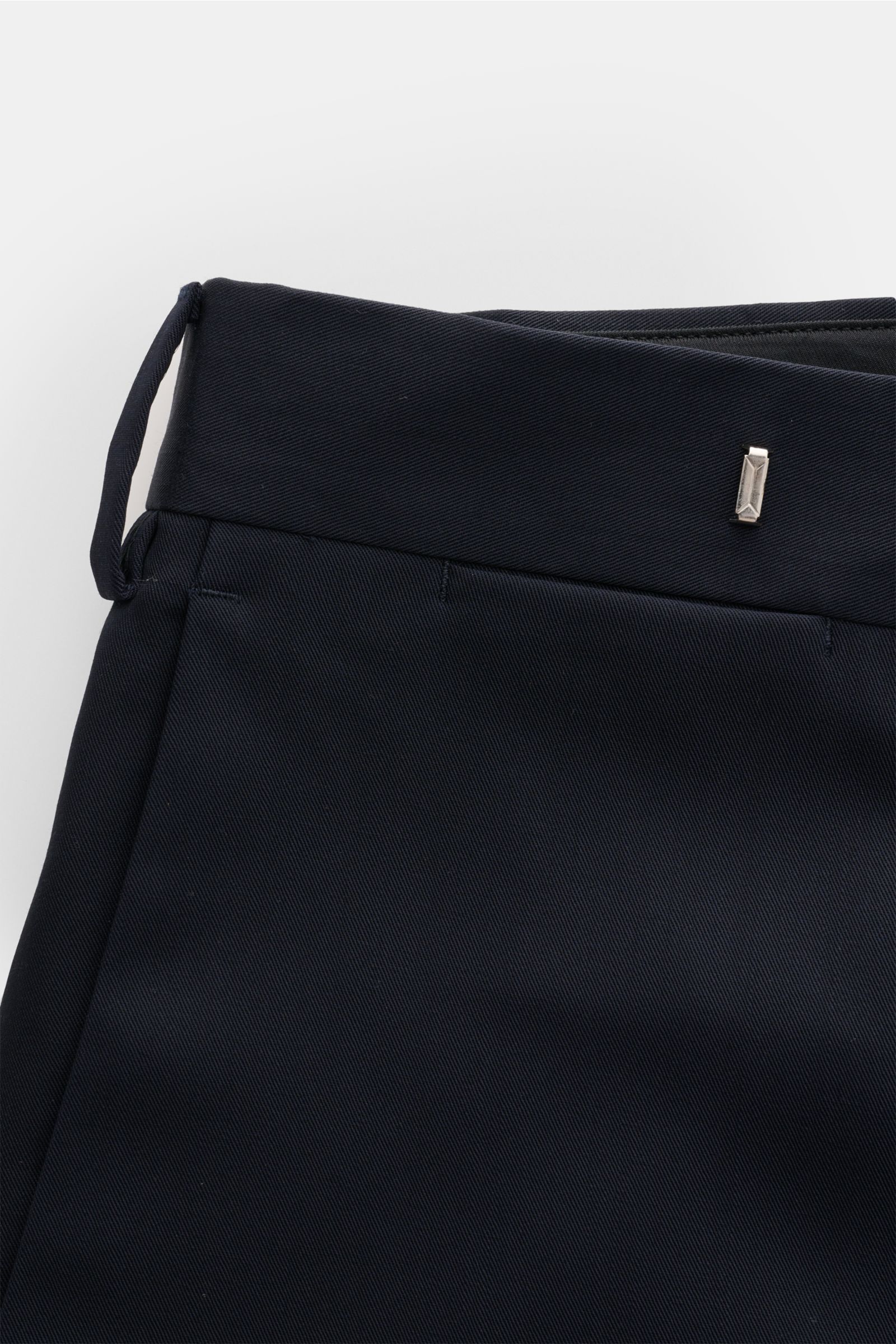 Nahaufnahme der Lardini Wollhose navy aus leichter reiner Wolle im Regular Fit, mit geradem Schnitt, Reißverschluss und Bundhaken, französischen Taschen, Uhrentasche und paspelierten Gesäßtaschen mit Knopf, fotografiert von oben.