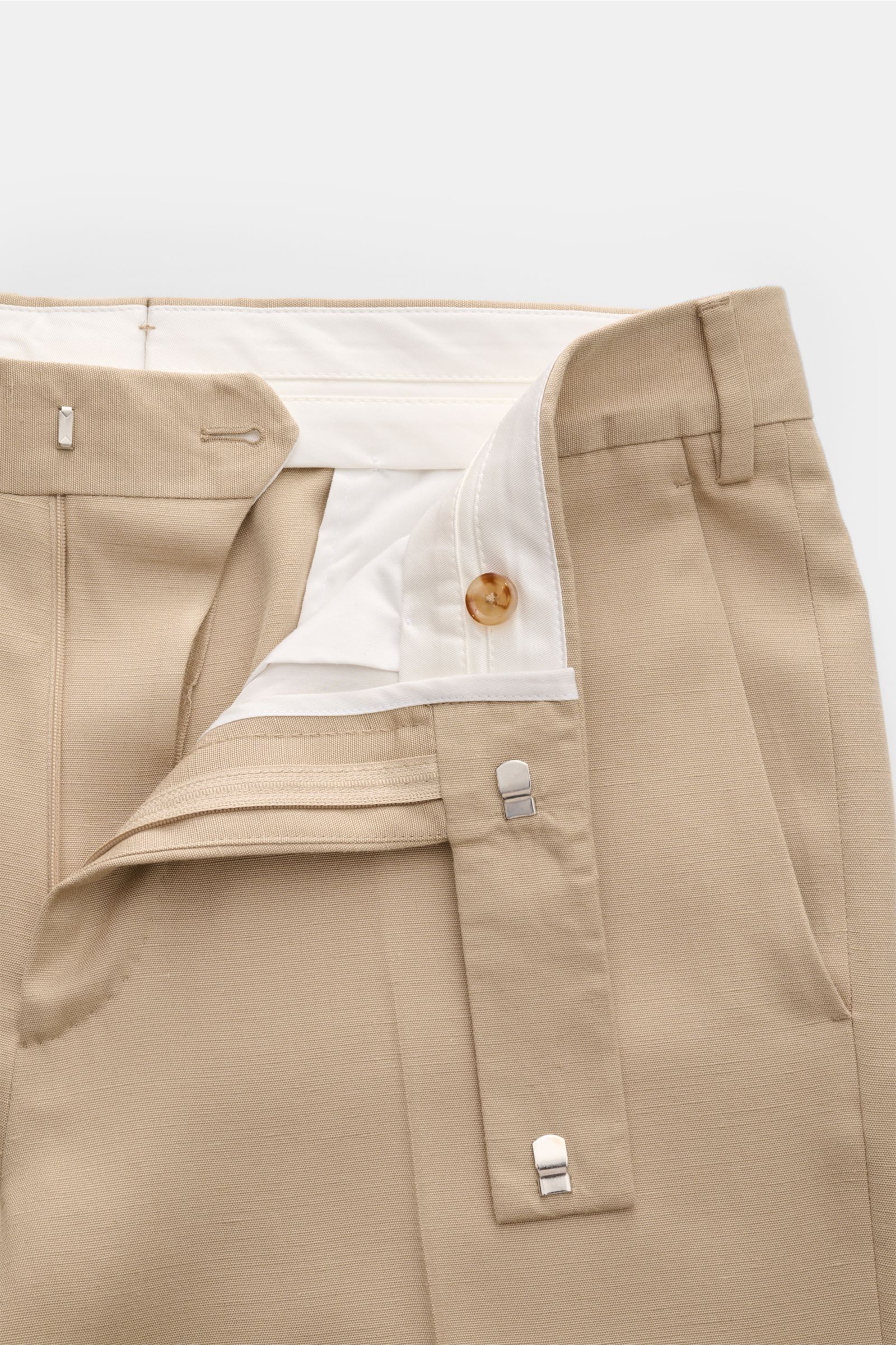 Close-up front view of Lardini Hose beige trousers showing the waistband, zipper, hooks, and light beige fabric with visible titerschwankungen in the weave. Edler Zwirn vom italienischen Traditionshaus LARDINI: aus leichter Viskose mit Anteil von Seide is