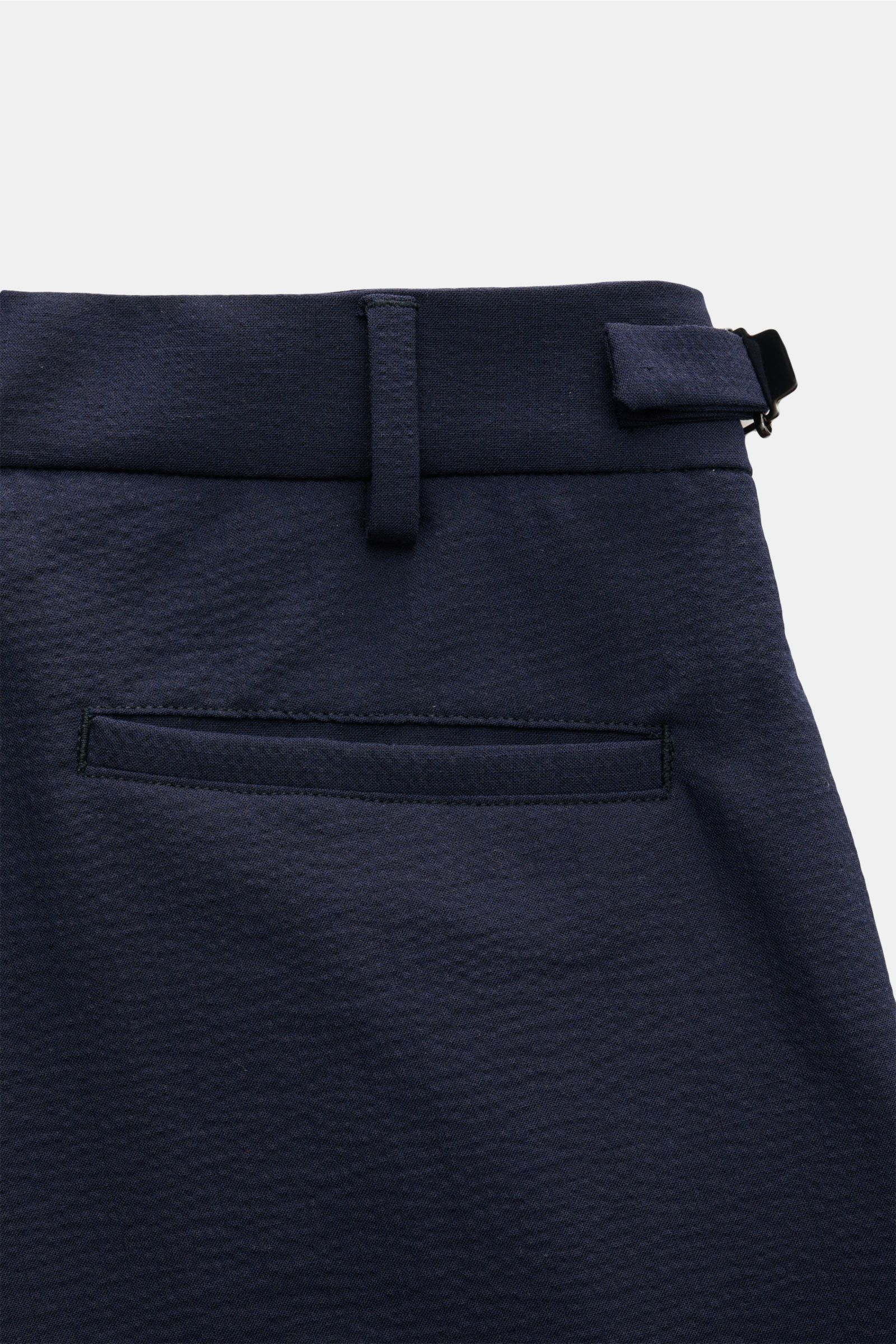 Close-up rear view of 04651/ A trip in a bag Seersucker trousers navy, showing tapered fit, regular thigh width, ankle length, zip and waist button, double pleat, side adjusters, French pockets, hip pockets on the seat, fixed hem turn-up, subtle woven lab