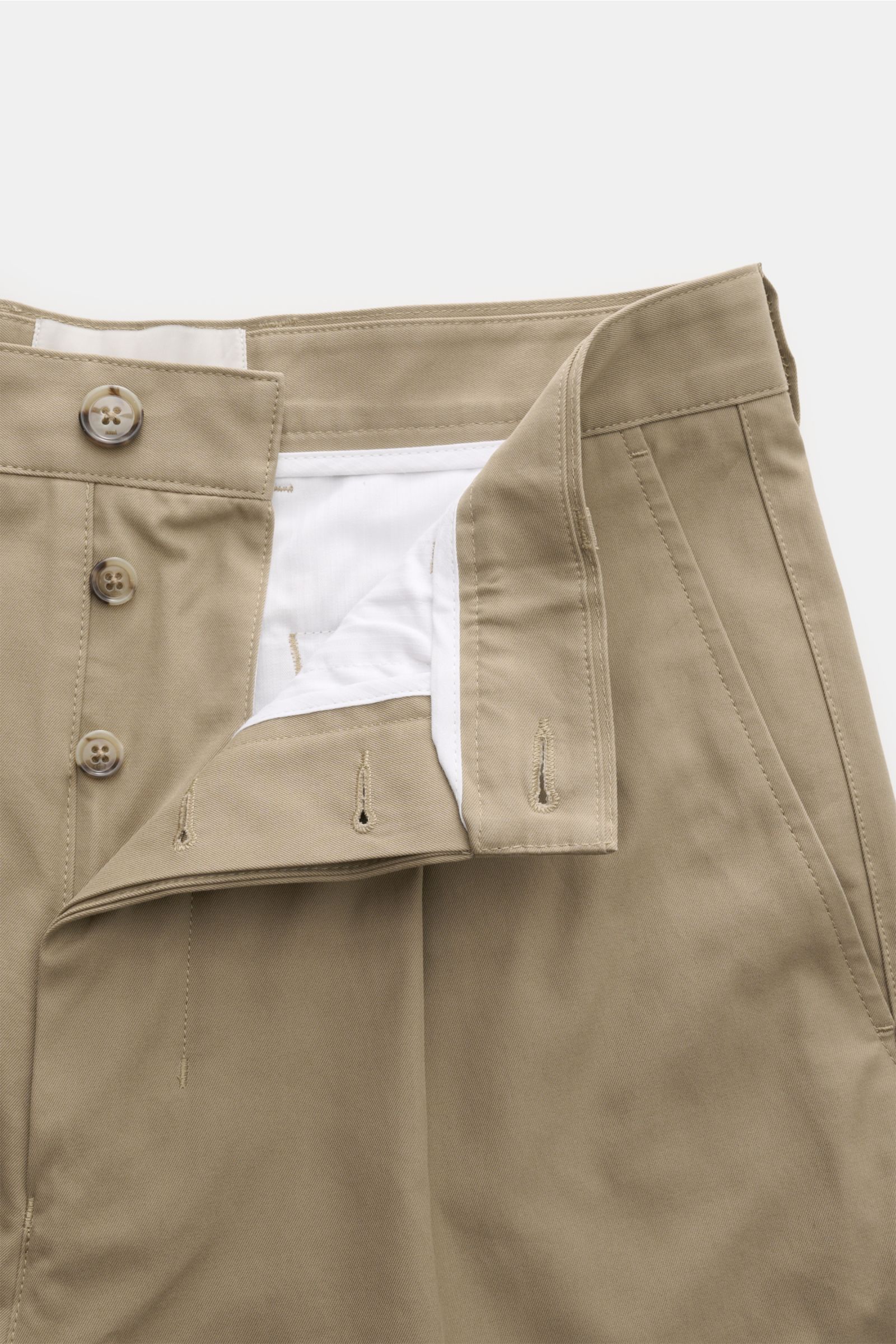 Nahaufnahme der geöffneten Ami Paris Chino 'Carrot Oversized' sand mit hohem Bund, fixiertem Saumaufschlag und Button Fly.