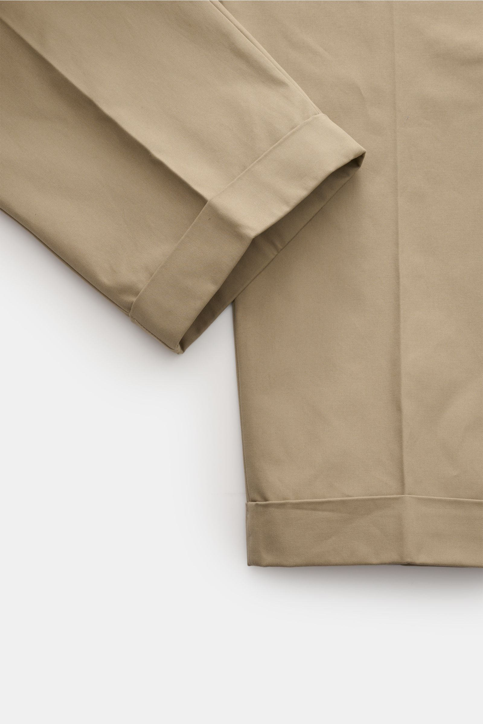 Nahaufnahme der fixierten Saumaufschläge der Ami Paris Chino 'Carrot Oversized' sand aus reiner Baumwolle mit tapered Fit.