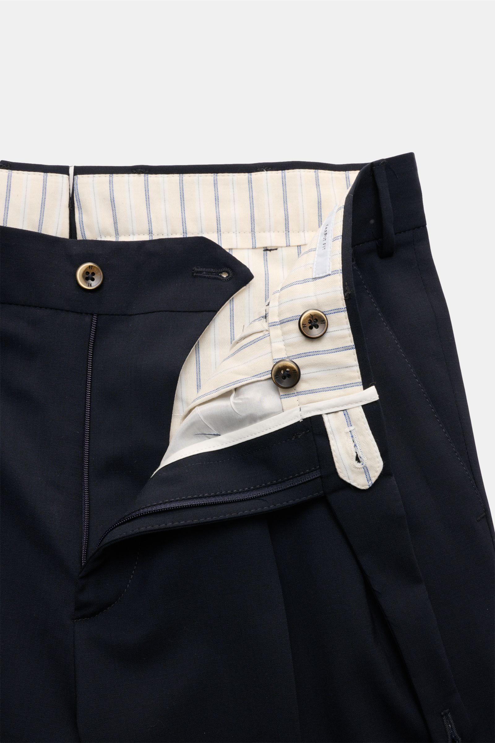 Close-up front view of PT Torino Wool trousers 'Carrot Fit' navy, showing open waistband with buttons, zip, and striped inner lining. Classic elegance with a modern twist: With their short cut, stylish pleats and extended buttoned tab, the trousers 'Carro