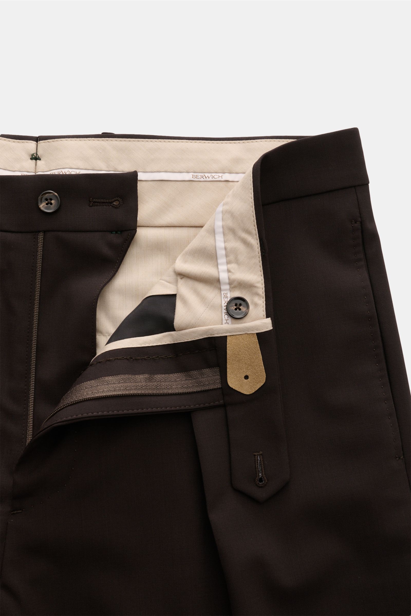 Close-up front view of Berwich Wool trousers 'Chiaia' dark brown showing the zip, waist buttons, and beige inner lining details.

The wool trousers 'Chiaia' by BERWICH give expression to traditional Italian tailoring with a modern tapered fit, slightly