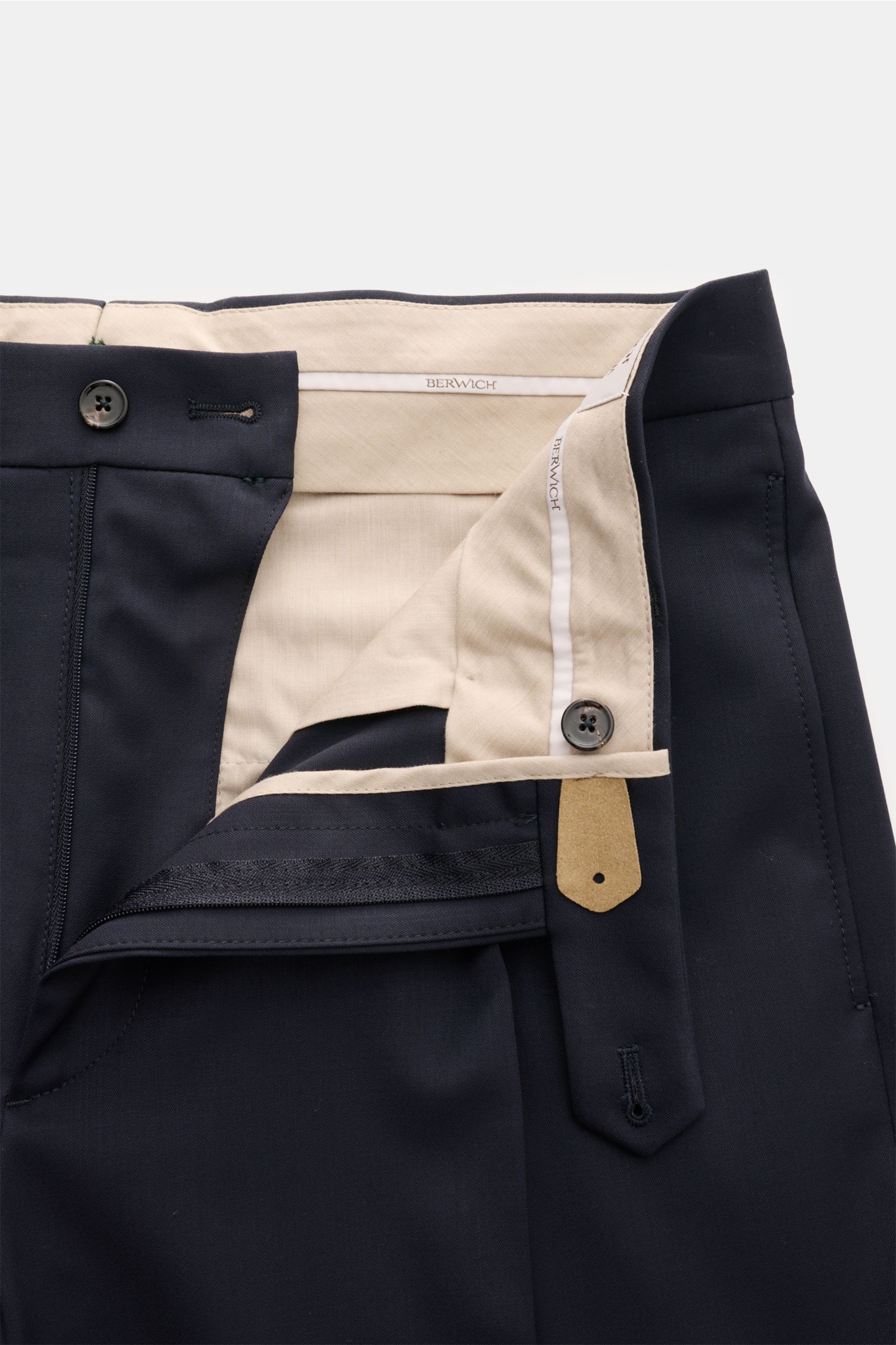 Close-up front view of Berwich Wool trousers 'Chiaia' navy showing zip, button waist, beige inner lining, and extended buttoned tab.

Description: The wool trousers 'Chiaia' by BERWICH give expression to traditional Italian tailoring with a modern tape
