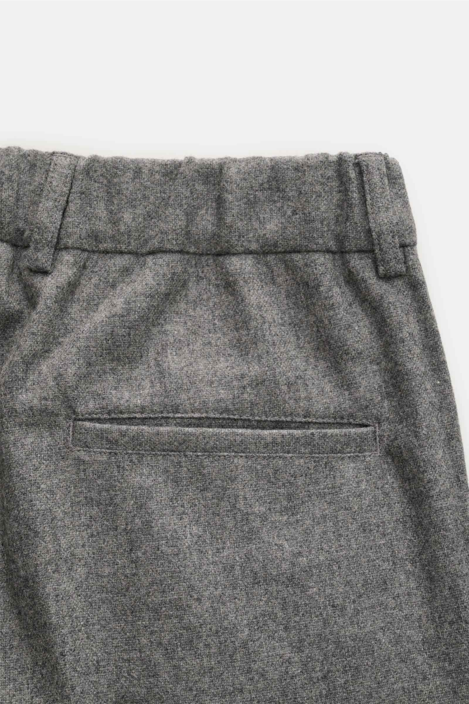 Graue melierte 04651/ A trip in a bag Hose, Detailaufnahme rückseitige paspelierte Gesäßtasche, weicher Woll-Microfaser-Mix, schmal zulaufend, Bund mit Knopf, Reißverschluss, doppelter Bundfalte, französische Taschen, fixierter Saumaufschlag.