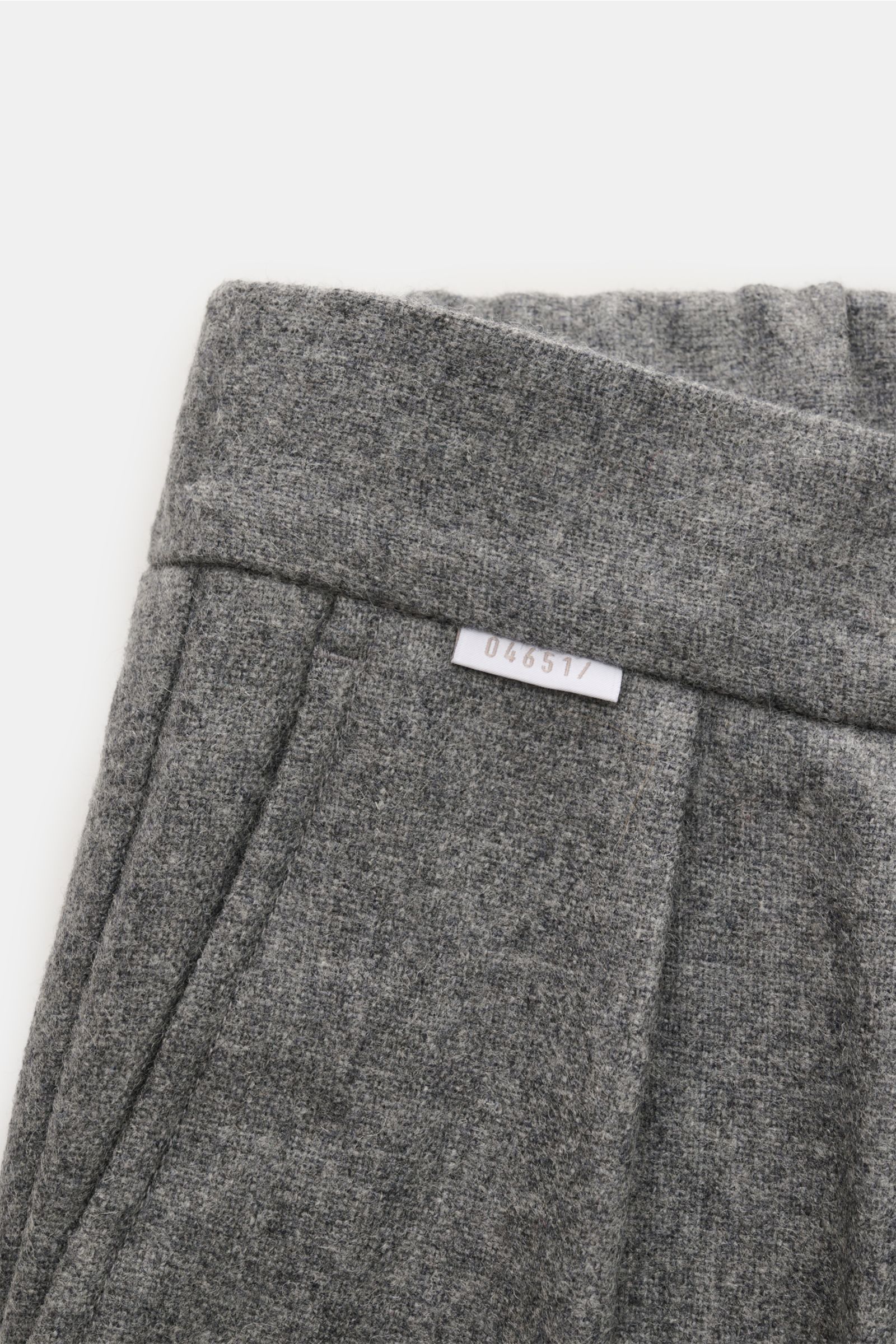 Nahaufnahme der 04651/ A trip in a bag Hose grau meliert aus Wolle-Microfaser-Mix, weicher Griff, Tapered Fit, Bund mit Label, französische Taschen.