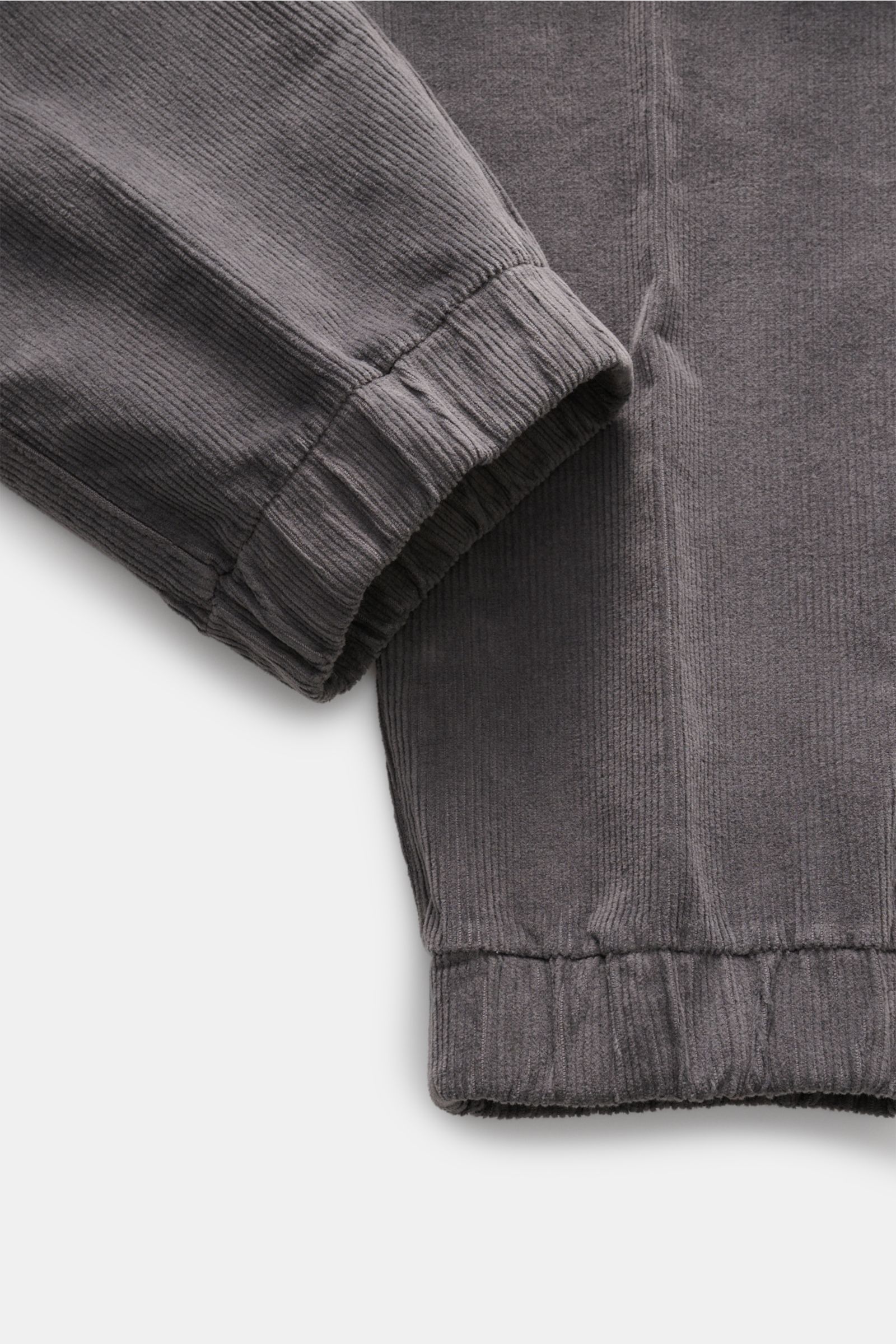 Close-up image of the elastic cuff and lower leg area of the 04651/ A trip in a bag Cord-Joggpants 'Smart Cord Cargo' oliv, showing soft cotton fine cord fabric with a very soft touch, slight stretch, and garment dyed finish from a top-down perspective.