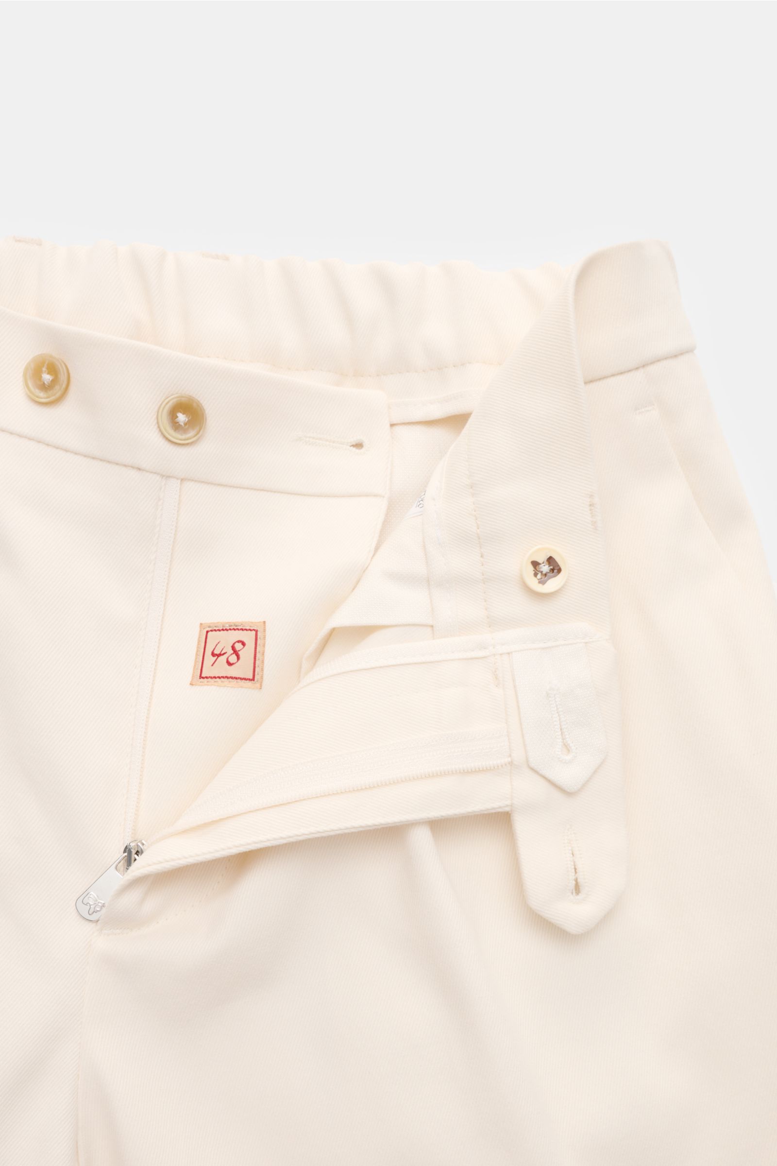 Close-up front view of the Marco Pescarolo Chinos 'Far' creme showing soft twill cotton-cashmere fabric, zipper, buttons, and part-elastic waistband.

Description: Die softe Chino 'Far' aus dem Hause MARCO PESCAROLO vereint Komfort aus edlem Baumwoll-M