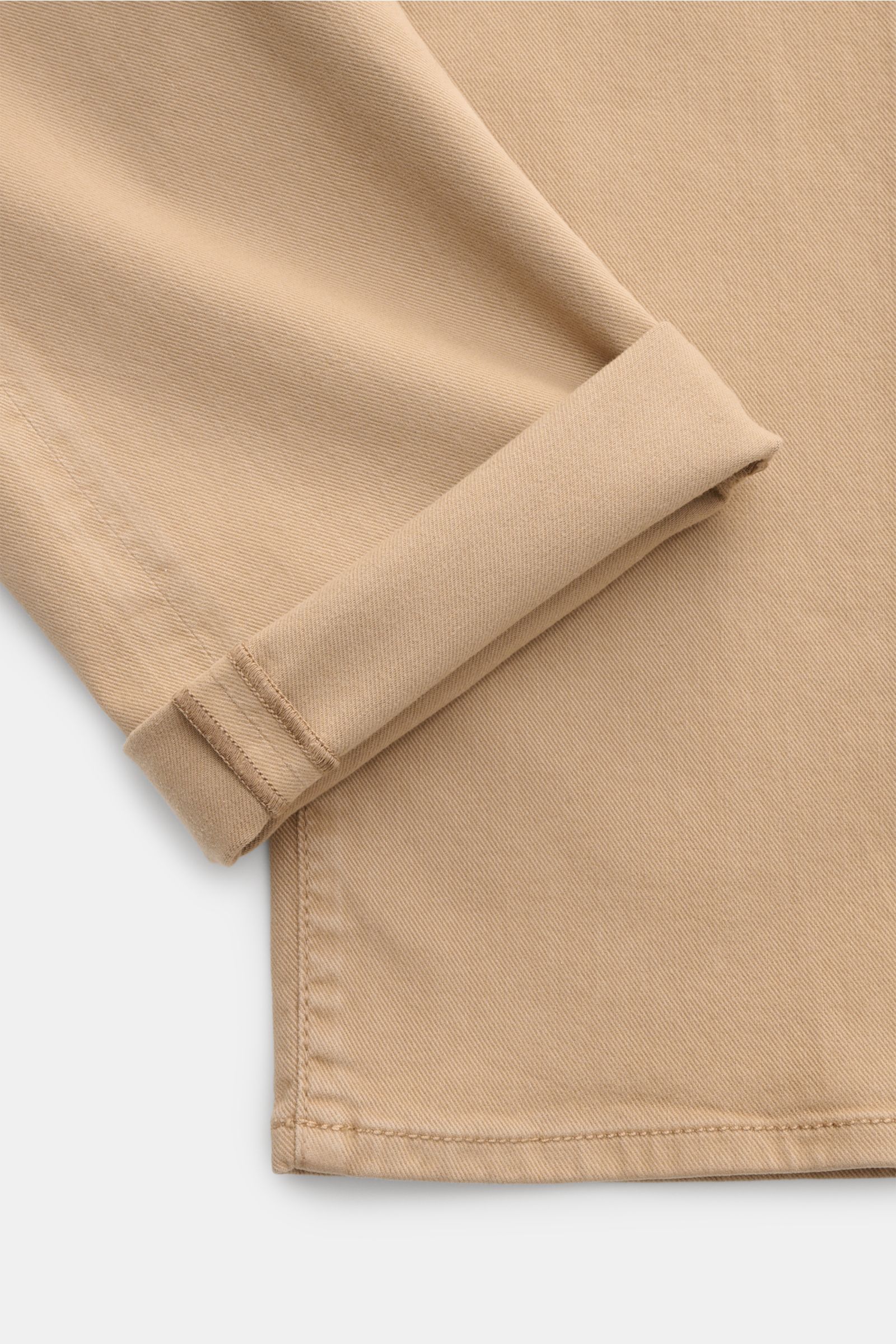 Close-up view of the lower leg and cuff of the Jacob Cohen Hose 'Bard' beige, showcasing twill cotton and lyocell fabric with tonal stitching. Setzen Sie Anspruch auf Stil und Qualität mit der klassischen Five-Pocket-Hose 'Bard' von JACOB COHEN im Slim