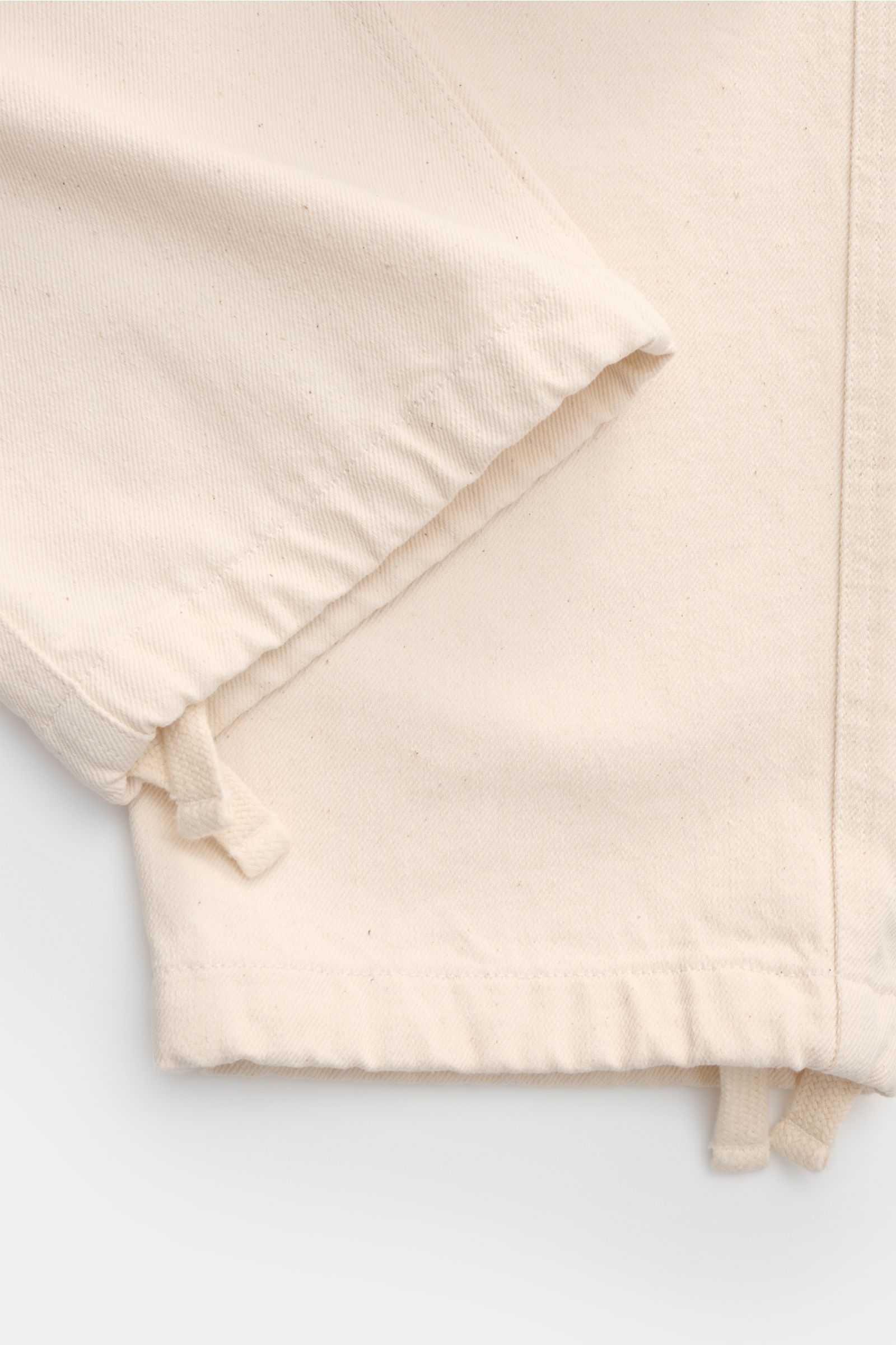 Close-up front view of Stone Island Jogger pants 'Raw Beauty' cream showcasing elasticated waistband, drawstring, and robust pure cotton twill fabric.

These robust jogger pants called 'Raw Beauty' by STONE ISLAND are made of distinctive pure cotton tw