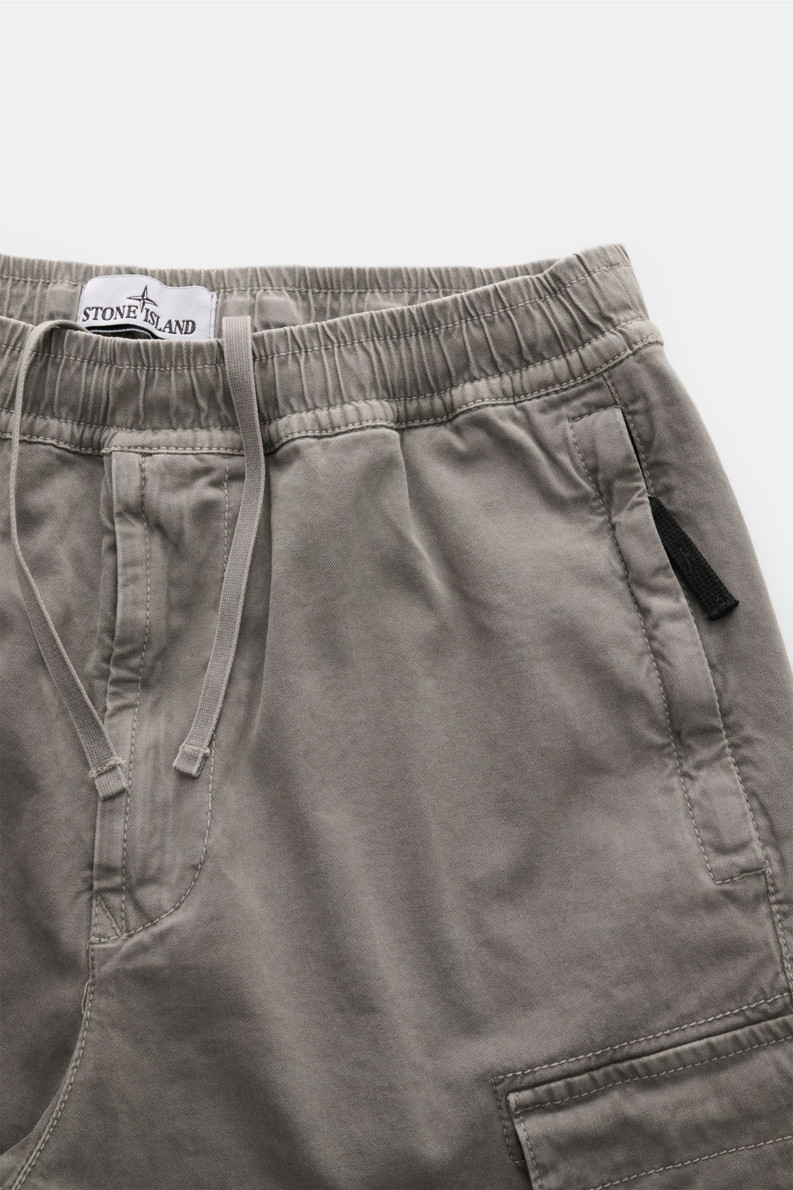 Stone Island Cargo-Jogpants grau aus stückgefärbter Bio-Baumwolle, elastischer Bund, Tunnelzug, Taschen, Kompass-Badge, Detailaufnahme frontal.