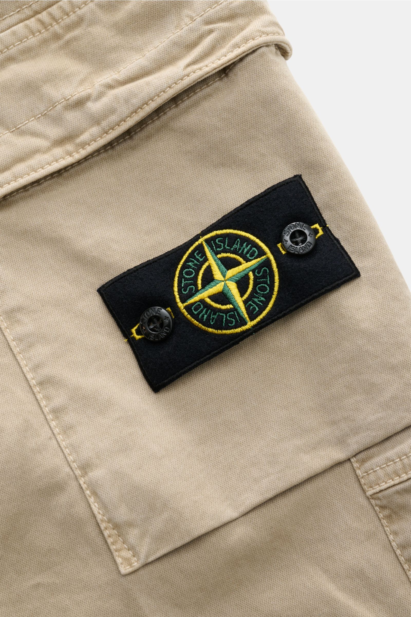 Stone Island Cargo-Jogpants beige Nahaufnahme der klassischen Cargo-Tasche mit Kompass-Badge aus elastischer Bio-Baumwolle.