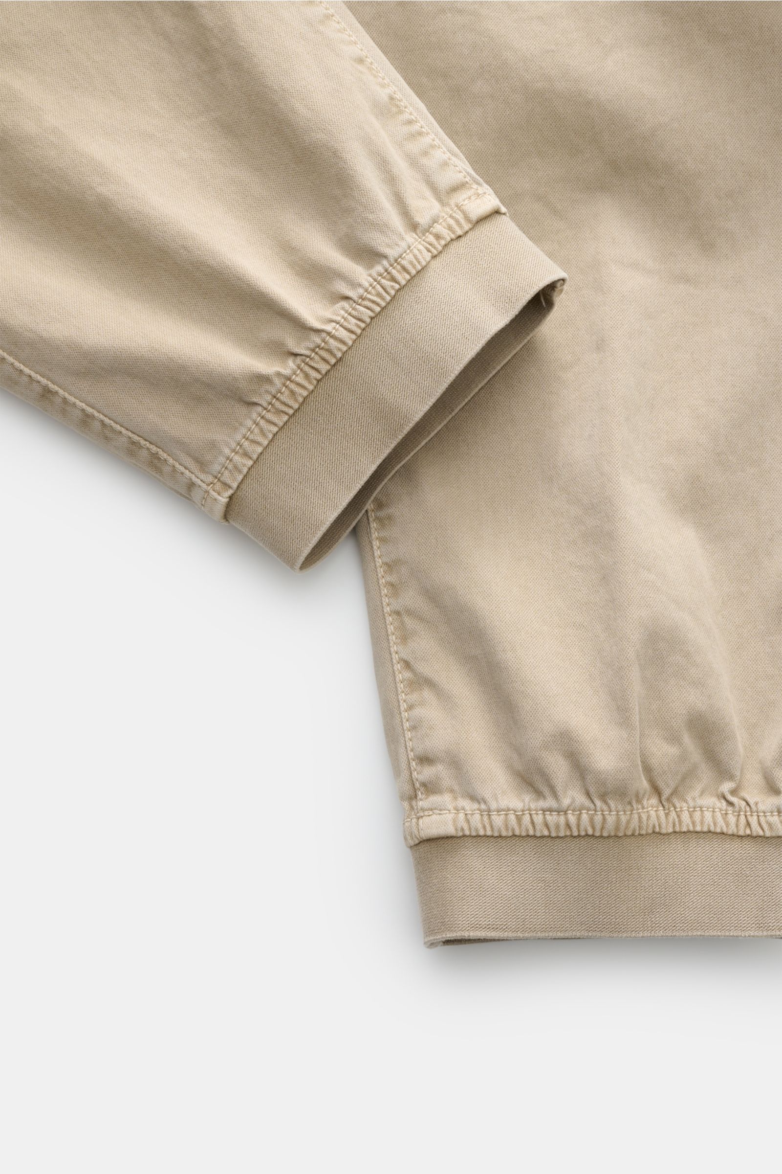 Stone Island Cargo-Jogpants beige, Detailaufnahme des elastischen Bunds und Beinabschlusses aus stückgefärbter Bio-Baumwolle.