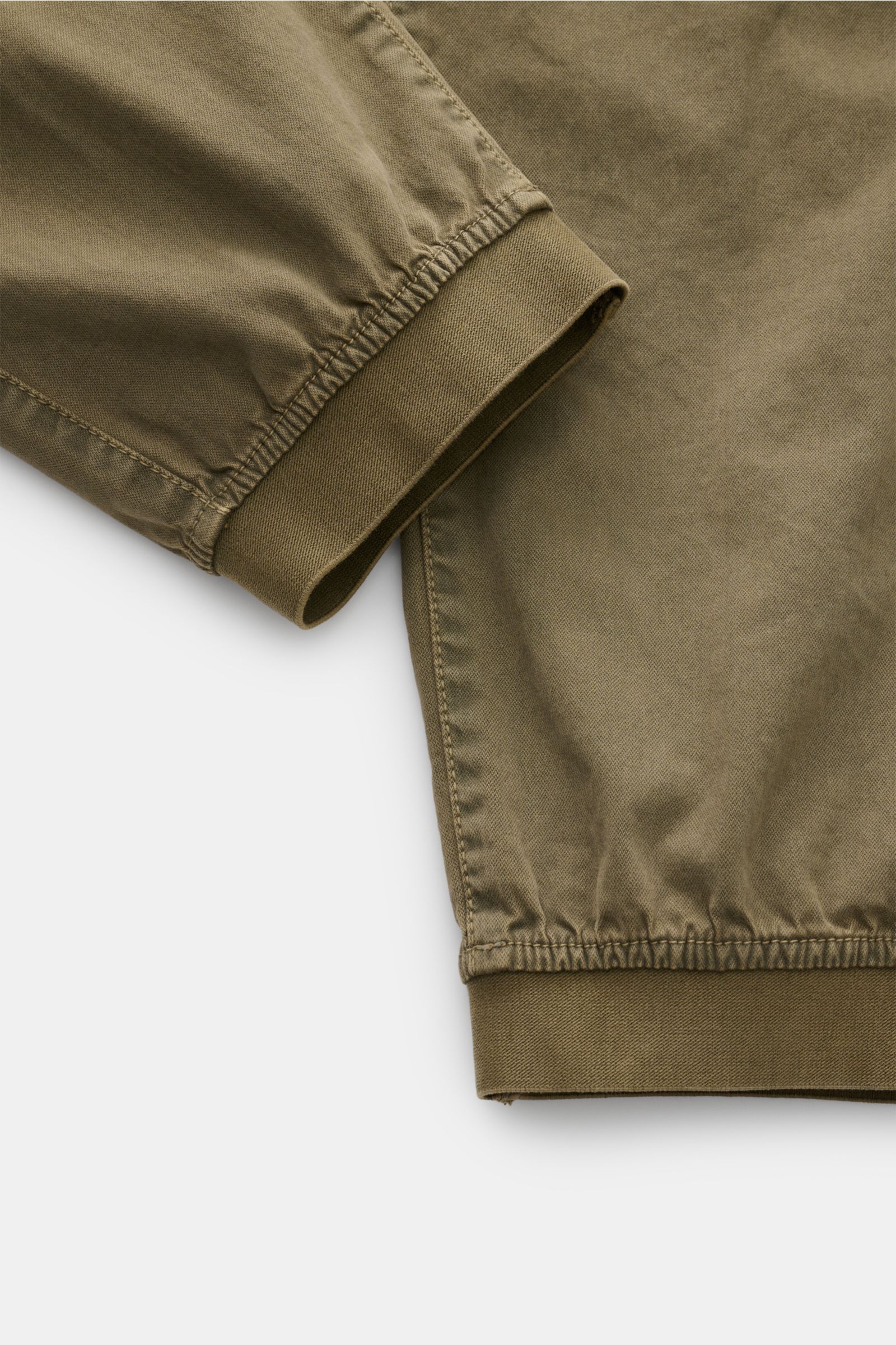 Detailaufnahme der Stone Island Cargo-Jogpants oliv von unten, zeigt elastische Beinabschlüsse aus stückgefärbter Bio-Baumwolle mit weichem Griff.