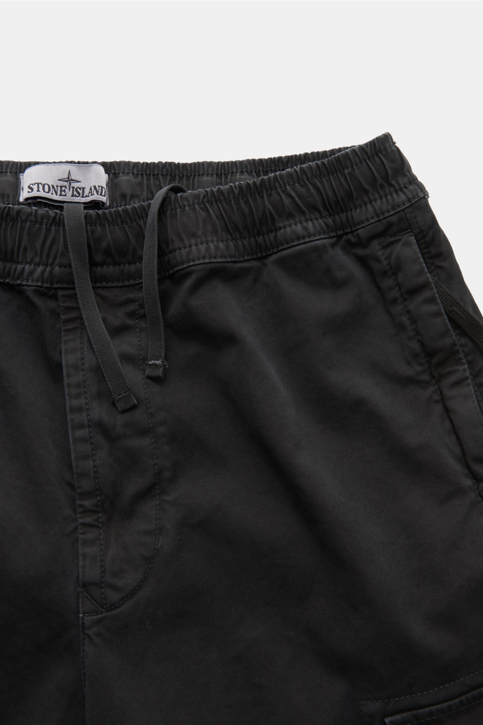 Close-up front view of Stone Island Cargo-Joggpants schwarz in black, made of leicht elastische Baumwolle with weicher Griff, garment dyed, Regular Fit, kurzer Schnitt, hohe Bundhöhe, elastischer Bund with innenliegendem Tunnelzug, Eingriff mit Reißversch