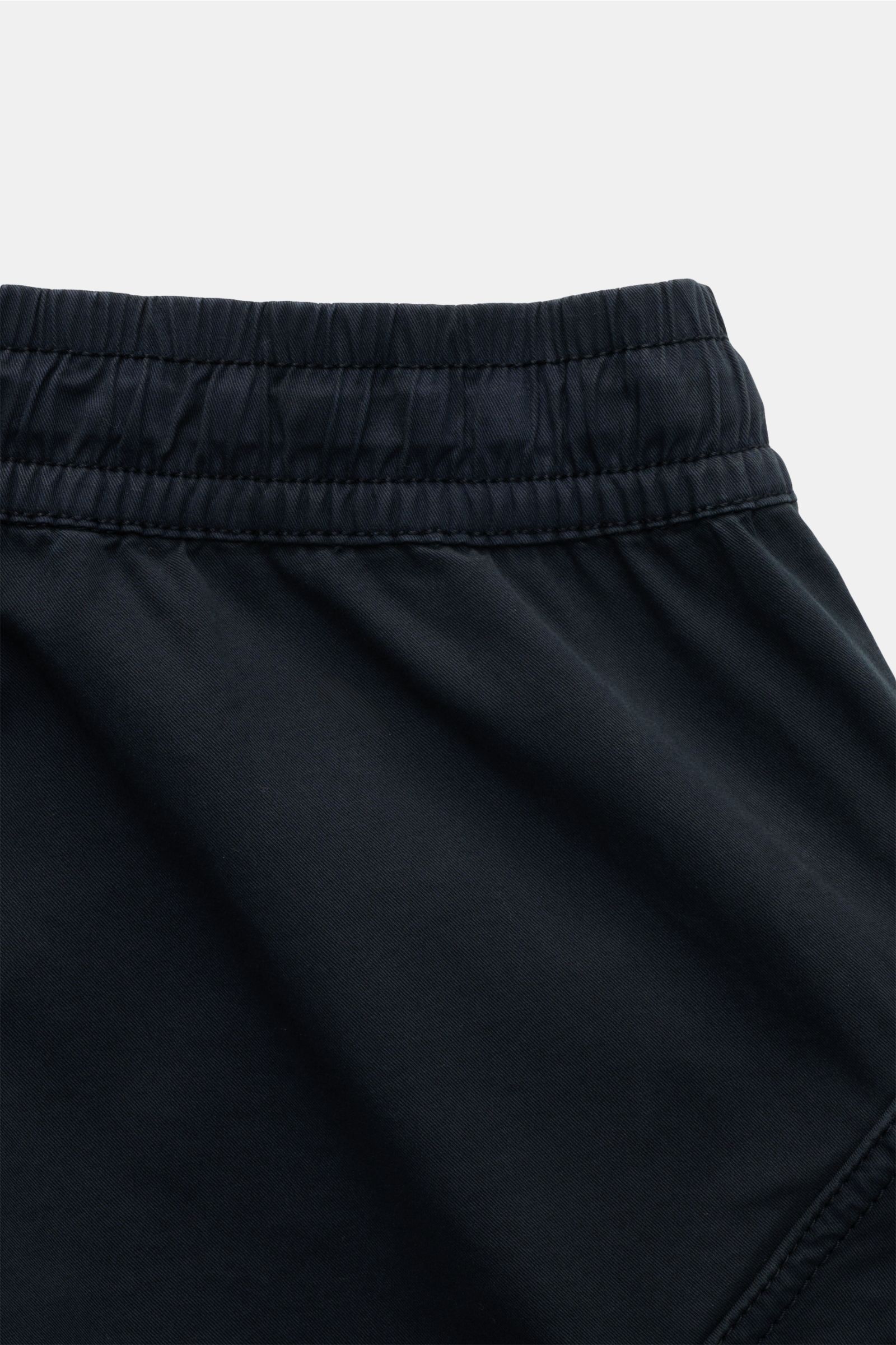 Close-up image of the waistband of Stone Island Joggpants navy, showing elastic band with stitching, photographed from a top-down perspective. These jogpants feature lightweight, slightly elastic cotton with a soft feel, garment dyed fabric, regular fit, 