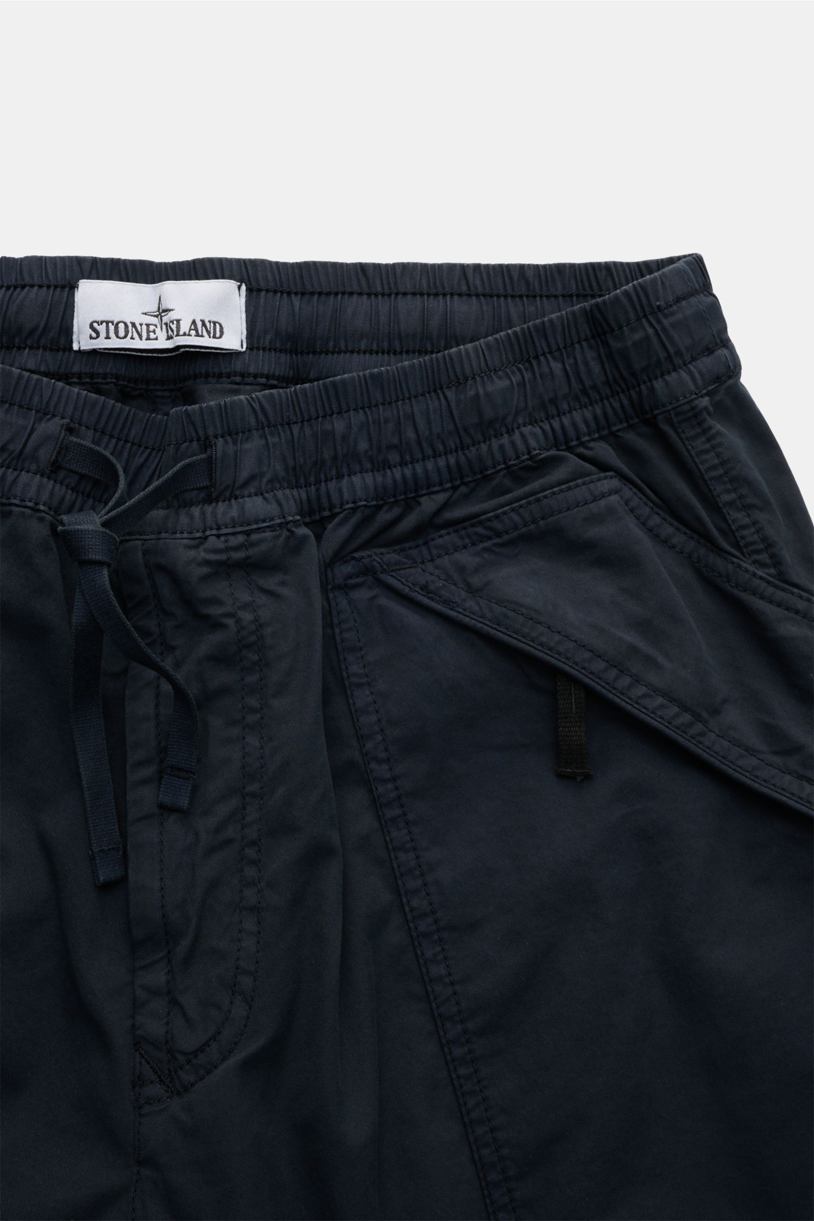 Close-up front view of Stone Island Joggpants navy made of lightly elastic, soft cotton with elastic waistband, drawstring, zippered pockets, and compass badge. Diese leger geschnittene Joggpants aus hochwertiger, leicht elastischer Baumwolle von STONE