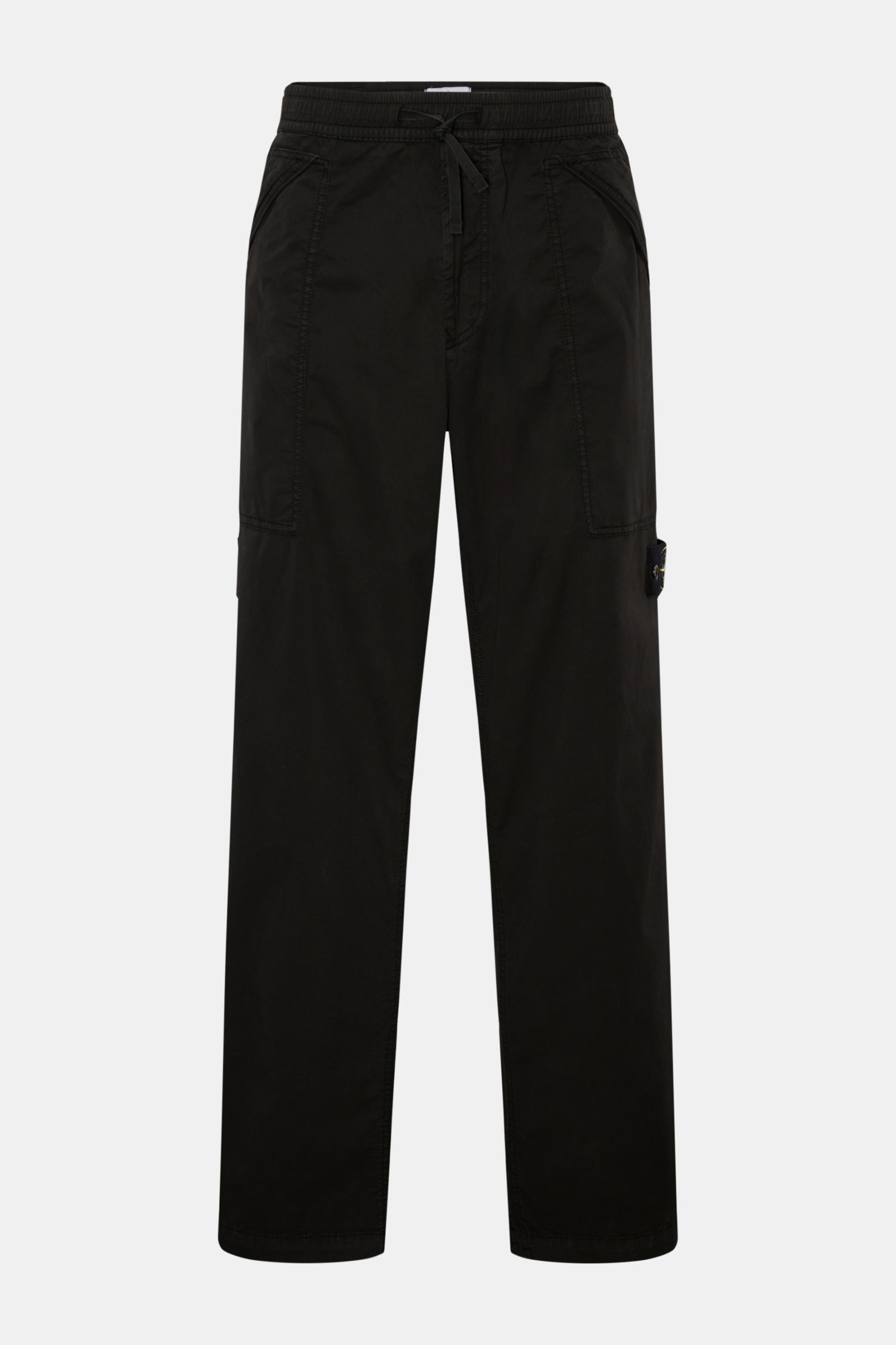 Front view of Stone Island Joggpants schwarz, casually cut black jogpants made of lightly elastic cotton, featuring soft touch, garment dyed fabric, regular fit, elastic waistband with drawstring, zippered fly, zippered patch hip pockets, and the typical 