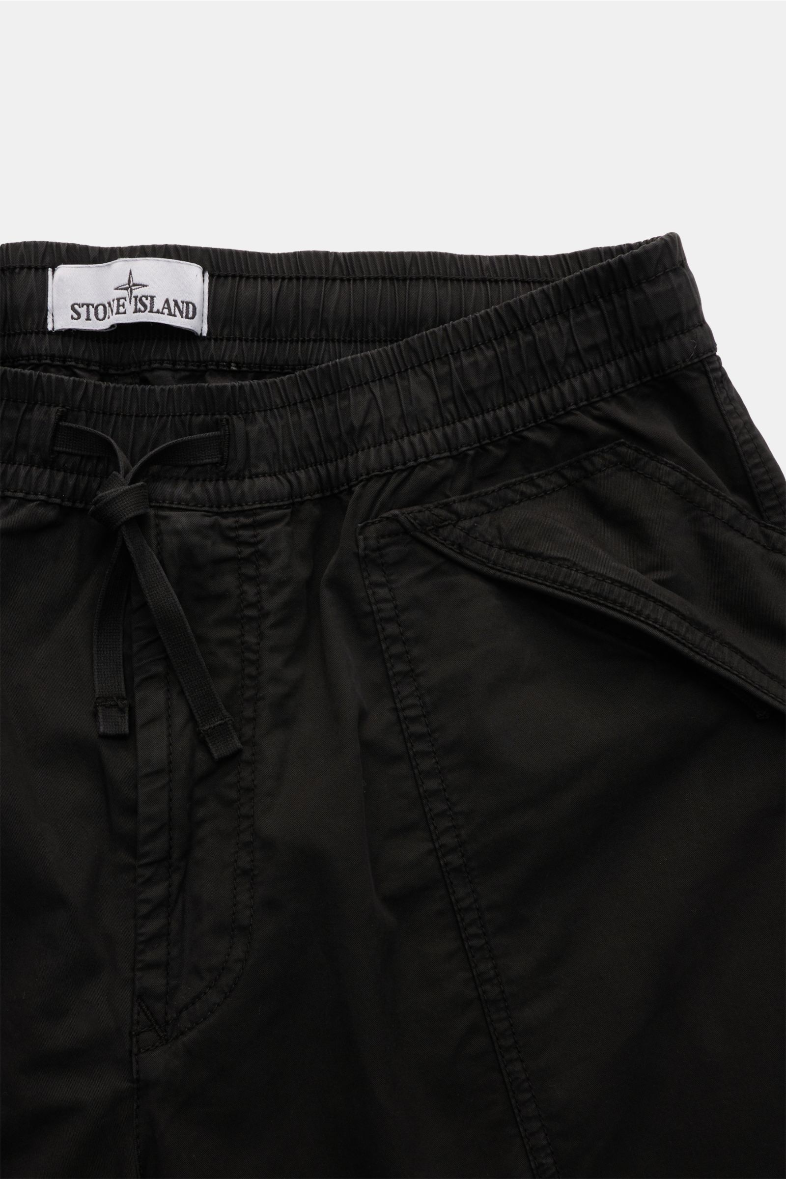 Close-up front view of Stone Island Joggpants schwarz showing elastic waistband with drawstring, zippered side pockets, and signature compass badge.  

Description: Diese leger geschnittene Joggpants aus hochwertiger, leicht elastischer Baumwolle von S
