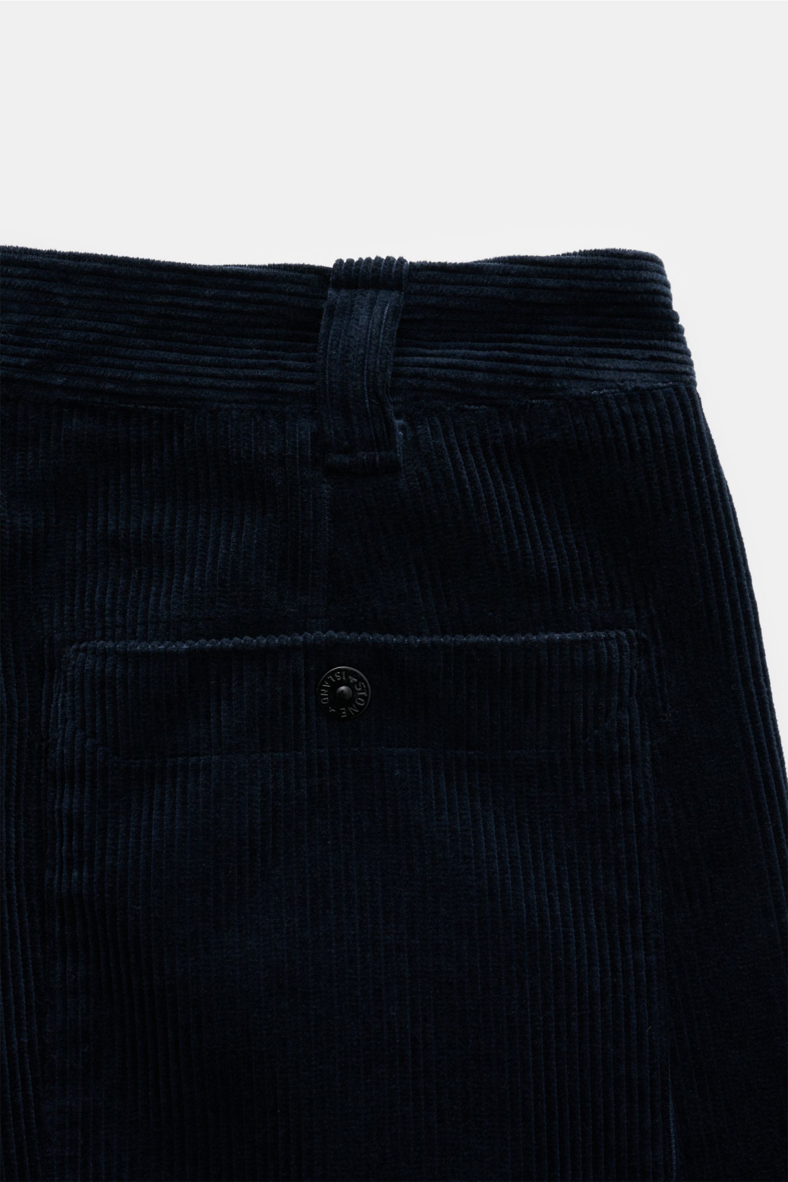 Close-up rear view of Stone Island Cord-Cargohose navy showing soft organic cotton corduroy fabric, back pocket with button, belt loop, and signature compass badge, with regular fit and straight cut detailed in the description.