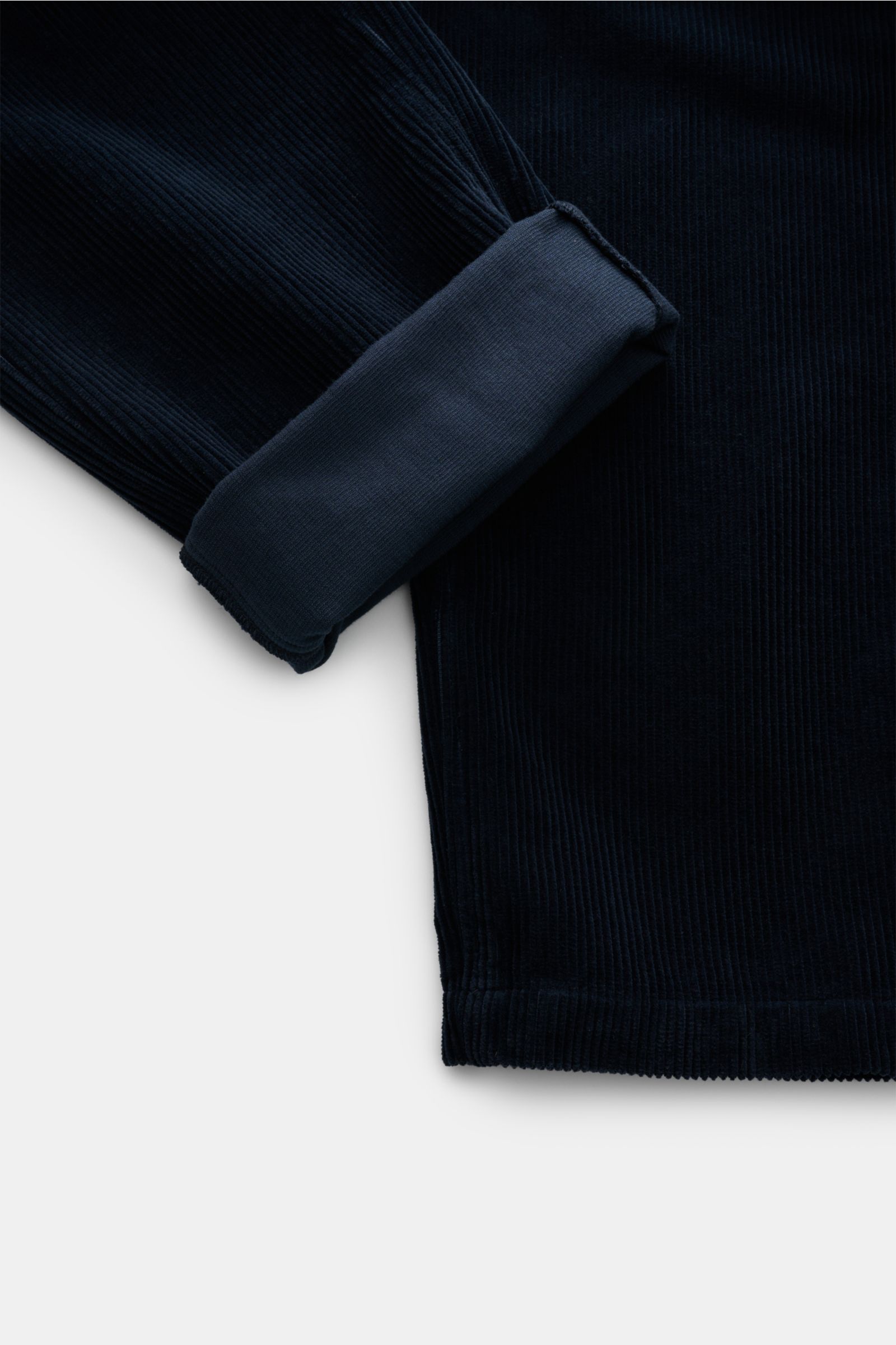 Stone Island Cord-Cargohose navy shown from a close-up side angle highlighting soft organic cotton corduroy, regular fit, straight cut, side and cargo pockets with snap buttons, zipper and button closure, and the iconic compass badge. Lässig und unverkenn