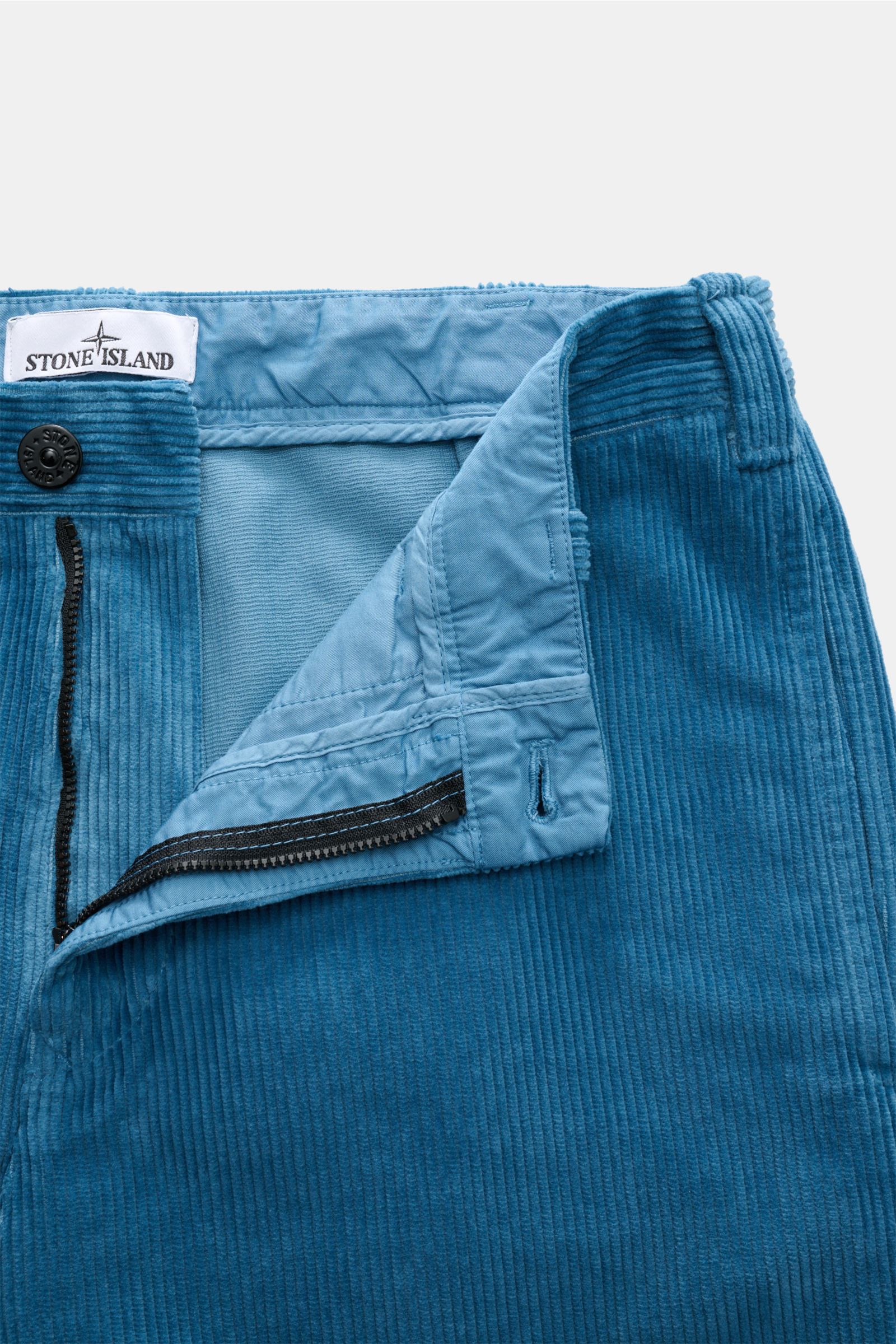 Stone Island Cord-Cargohose blau aus weichem Bio-Baumwoll-Cord, Frontansicht mit offenem Reißverschluss, Bundknopf und Kompass-Badge.