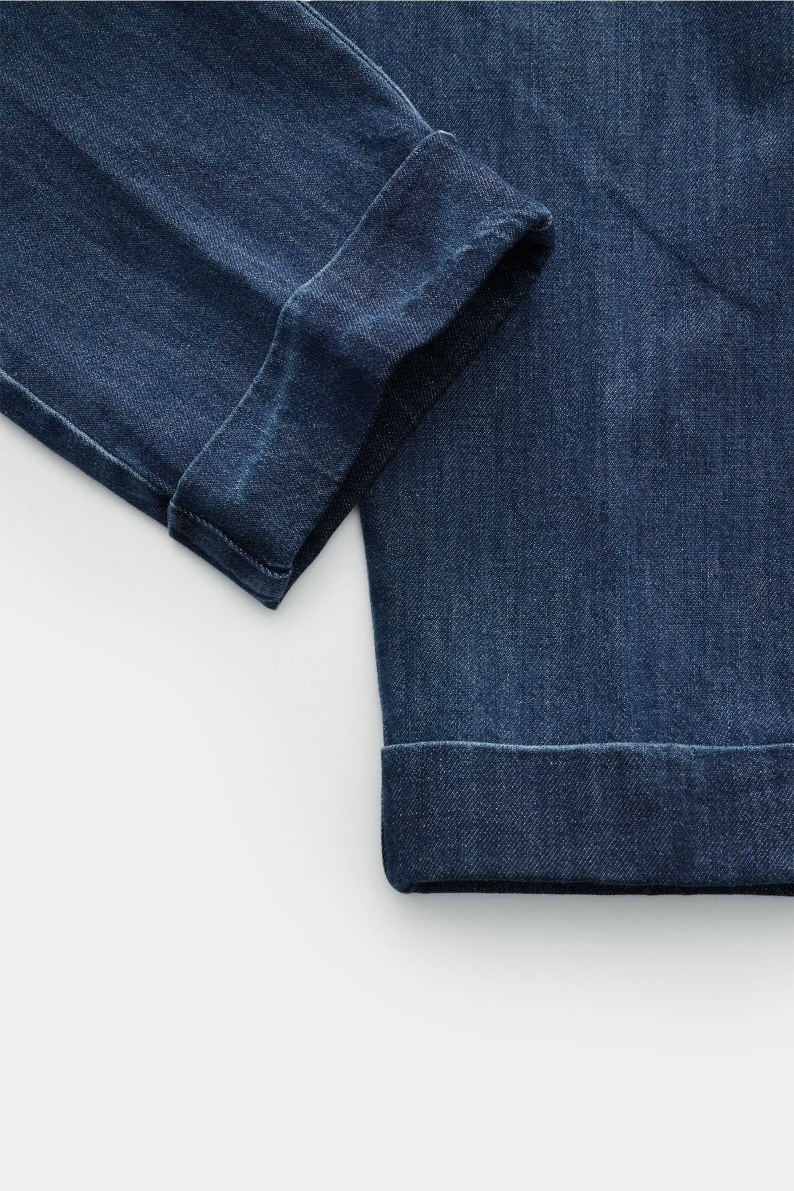 Close-up photo from the lower leg perspective of Berwich Jeans 'Chiaia 5t-GD' dunkelblau, showing folded cuffs in dark blue pure cotton twill with a soft feel. Die Jeans 'Chiaia 5t-GD' von BERWICH überzeugt mit modernem Tapered Fit, leichtem Twill aus 