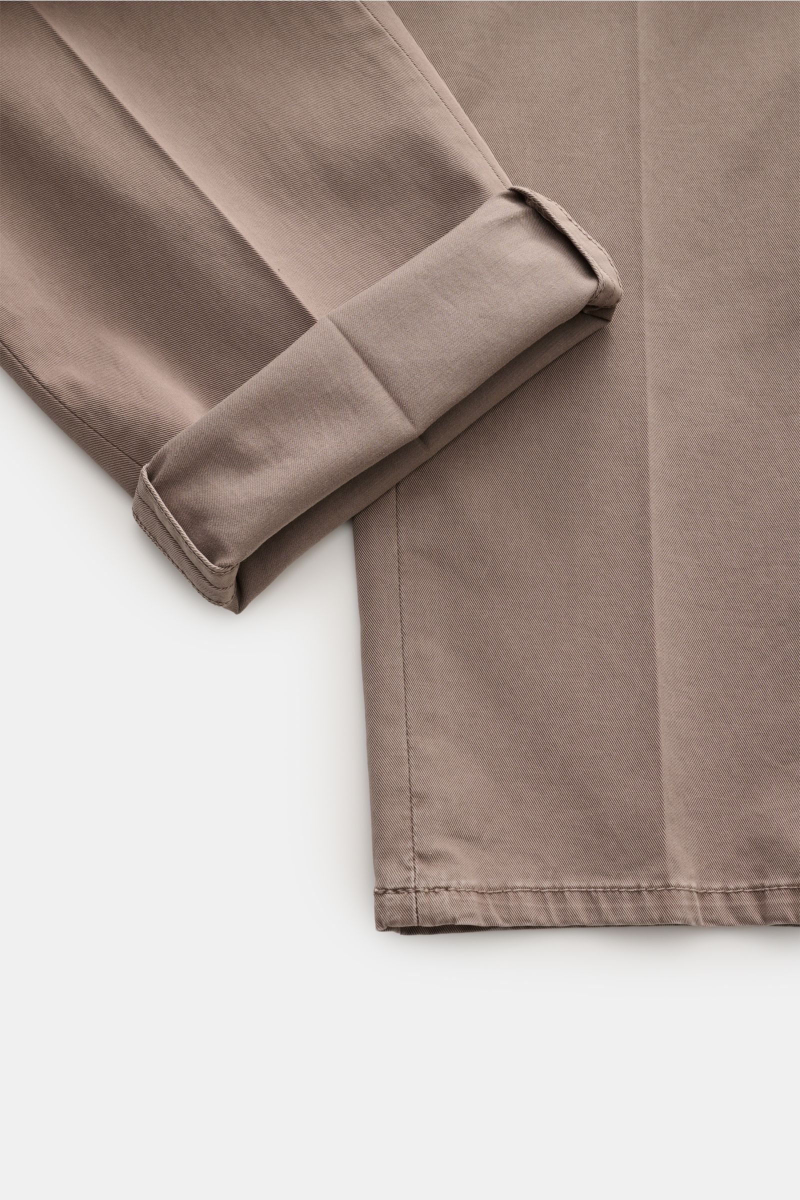 Brunello Cucinelli Chino 'Italian Fit' taupe shown from a close-up top-down perspective, highlighting the folded cuff and detailed stitching. Die Chino im 'Italian Fit' des Luxuslabels BRUNELLO CUCINELLI ist ein vielseitig kombinierbarer Klassiker und 