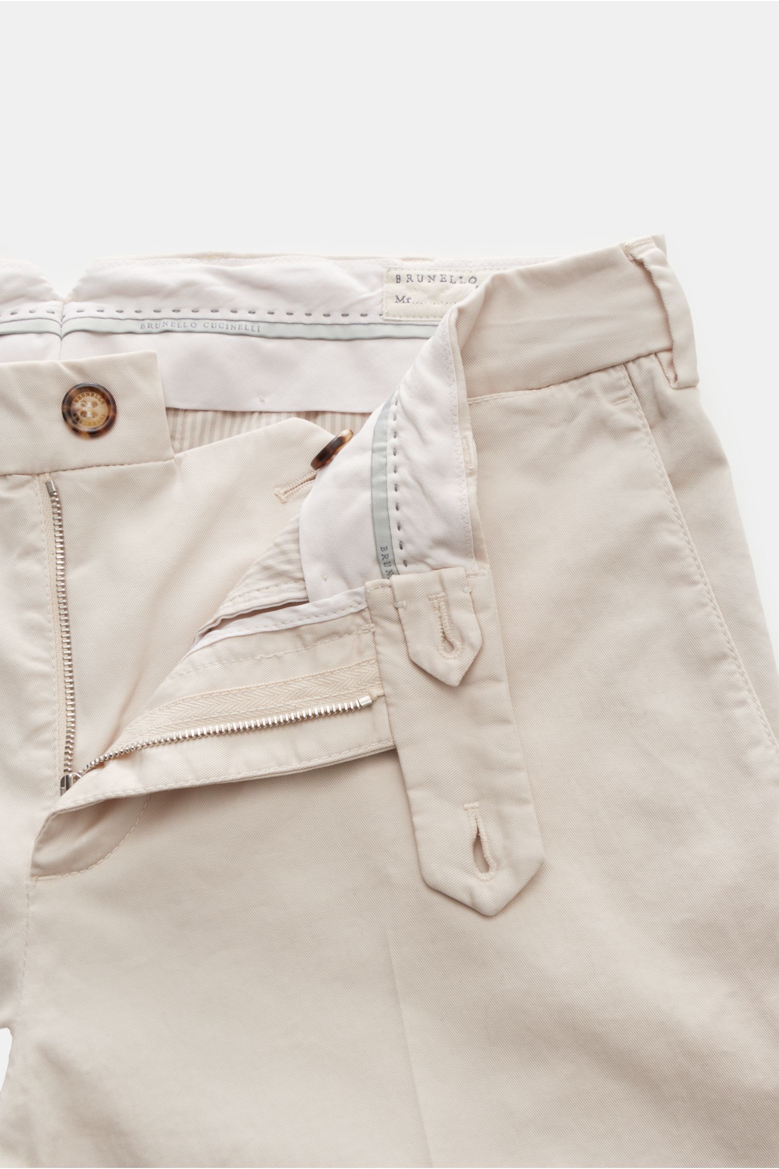 Brunello Cucinelli Chino 'Italian Fit' sand shown from a close-up front perspective, featuring twill cotton, lightly elastic, soft touch, regular fit, tapered, zipper and button closure, French pockets, small watch pocket, buttoned back pockets. Die Chino