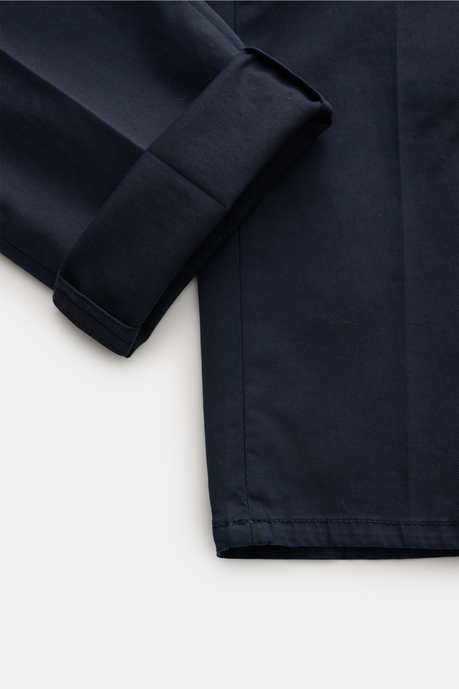 Brunello Cucinelli Chino 'Italian Fit' navy aus Baumwoll-Twill, Regular Fit, schmal zulaufend, weicher Griff, Detailaufnahme vom Saum und Ärmel.