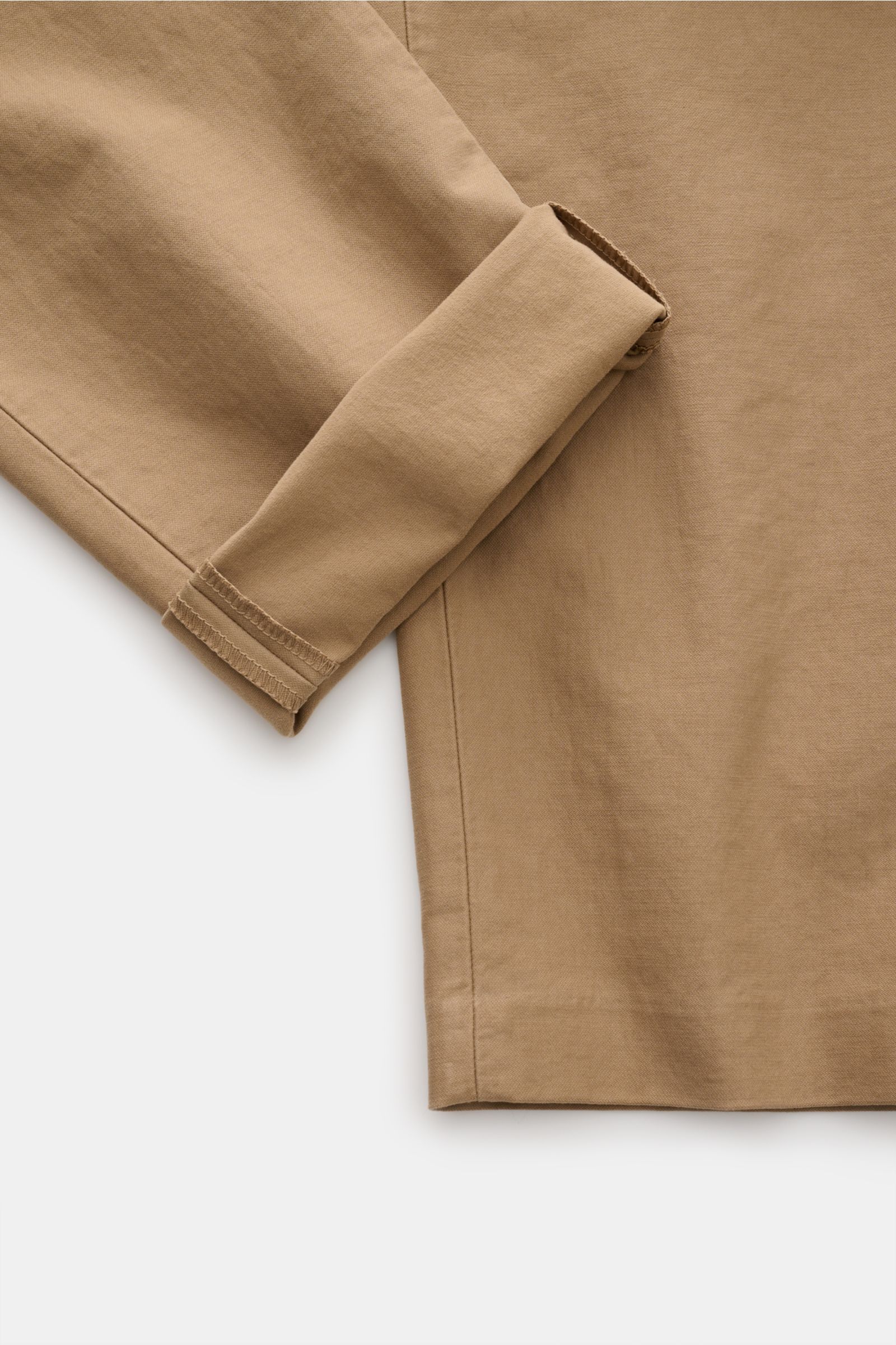 Das Bild zeigt einen Ausschnitt der Closed Baumwollhose 'Clifton' hellbraun, fotografiert aus seitlicher Perspektive, mit weichem Griff, Baumwolle mit Stretch-Anteil, garment dyed, Regular Fit, leicht schmal zulaufend, Reißverschluss und Bundhaken, franzö