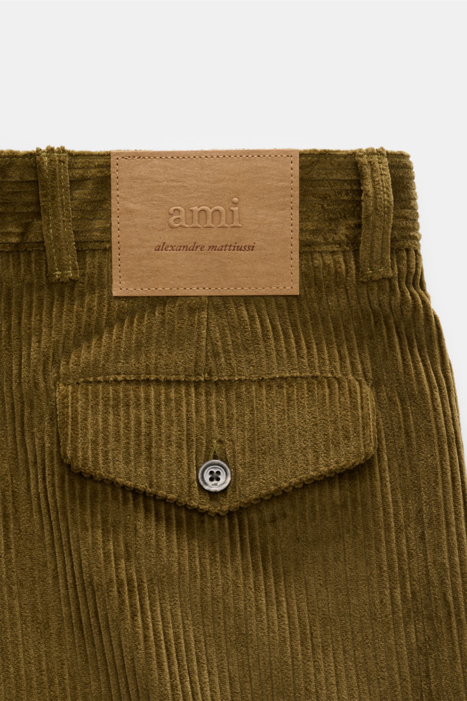 Close-up rear view of Ami Paris Cordhose oliv in dense olive cotton corduroy with buttoned back pocket flap and stitched leather logo patch.

Description: Mit lässiger Eleganz und französischem Esprit verleiht diese Karottenhose von AMI PARIS jedem Auftri