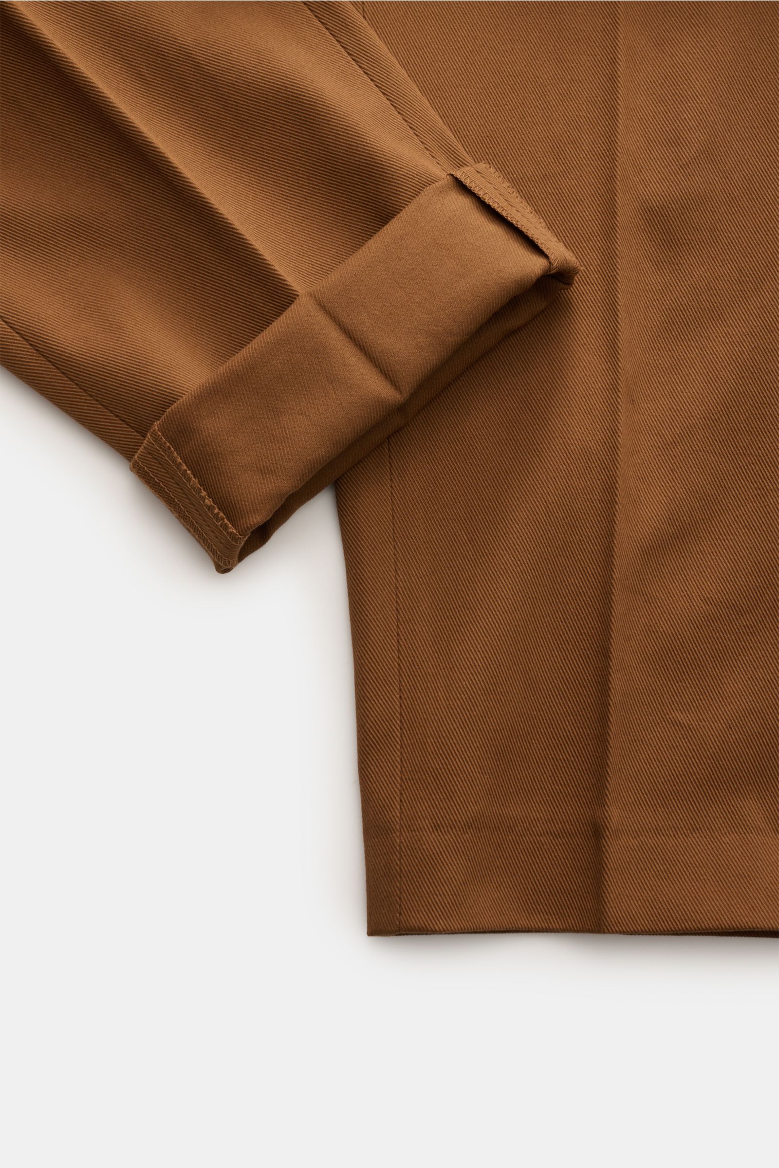 Nahaufnahme von umgeschlagenem Bein der PT Torino Chino 'Rebel Fit' braun, Twill aus reiner Baumwolle, griffige Haptik, garment dyed, tapered Fit, reguläre Oberschenkelweite, knöchellang, Reißverschluss und Bundhaken, französische Taschen, paspelierte Ges