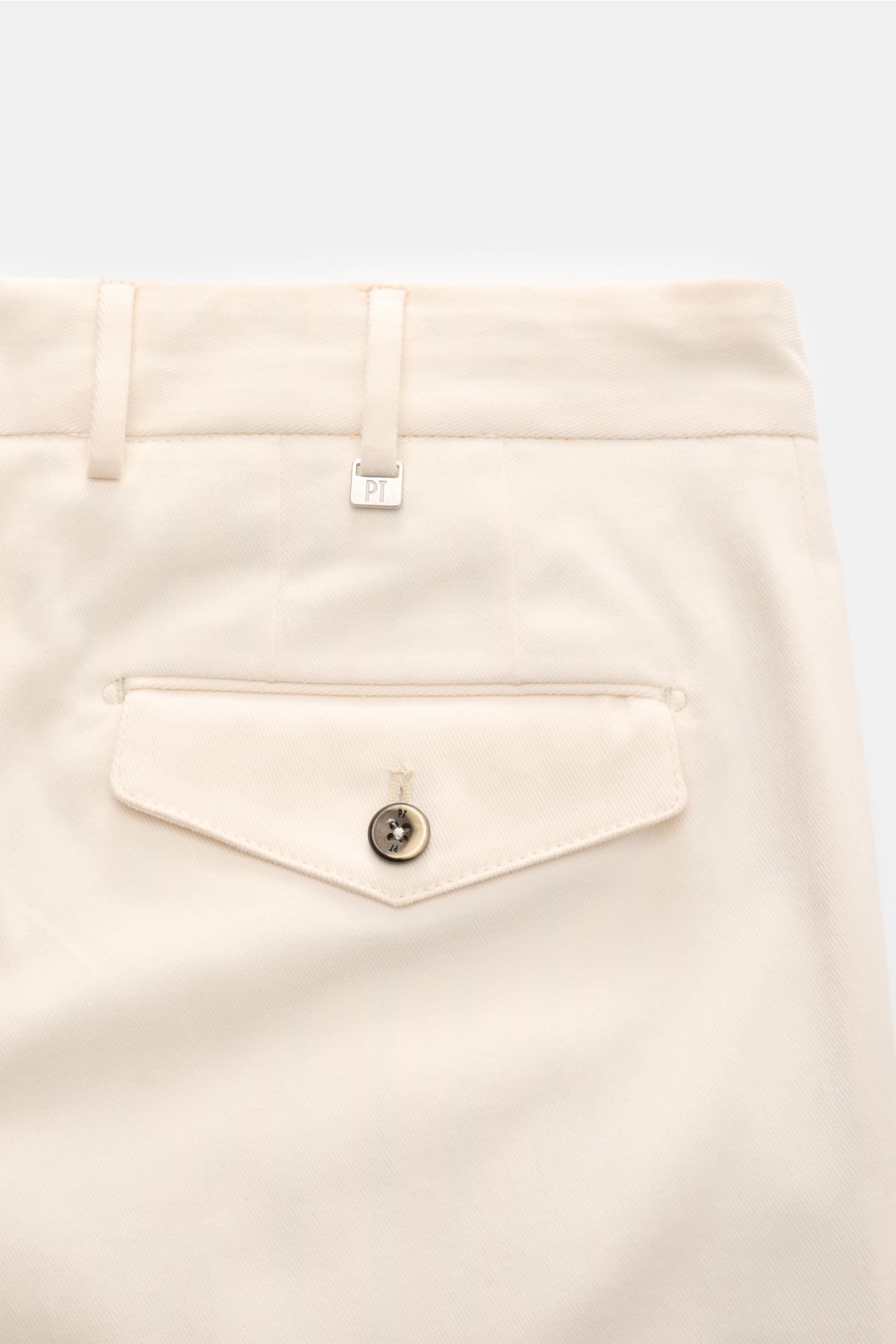 Close-up rear view of PT Torino Chino 'Carrot Fit' creme showing a buttoned flap pocket, belt loops, and soft twill cotton fabric with subtle texture. 

Description: Mit ihrem kurzen Schnitt, stilvollen Bundfalten und einem verlängerten Knopfriegel bringt
