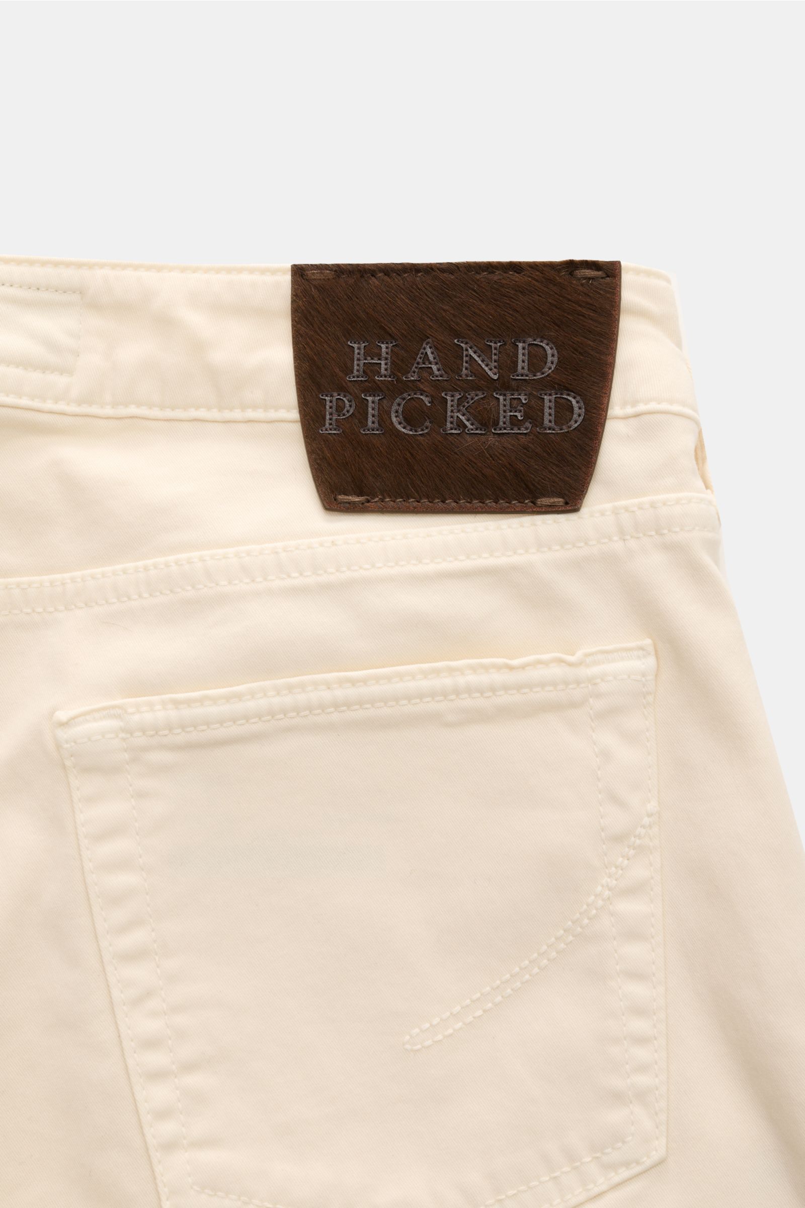 Back view of HandPicked Chinos 'Parma' cream made of cotton twill with slightly elasticated fabric, soft feel, slim fit, very tapered cut, button fly, French pockets, coin pocket with initial, back pockets with stitching, and a leather patch in pony skin 