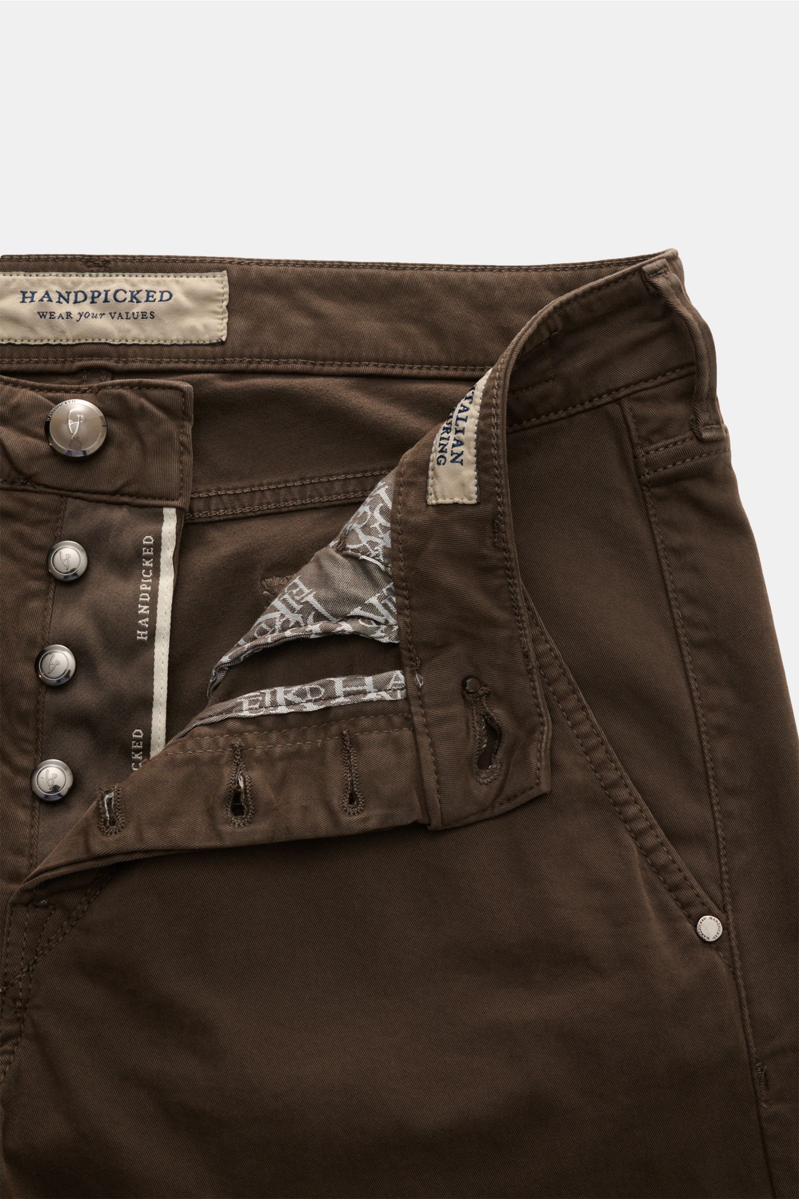HandPicked Chino 'Parma' dunkelbraun aus Baumwoll-Twill, Slim Fit, Button Fly, französische Taschen, Münztasche mit Initial, Gesäßtaschen mit Stitching, Leather Patch in Ponyfell-Optik, Detailaufnahme von vorne oben.