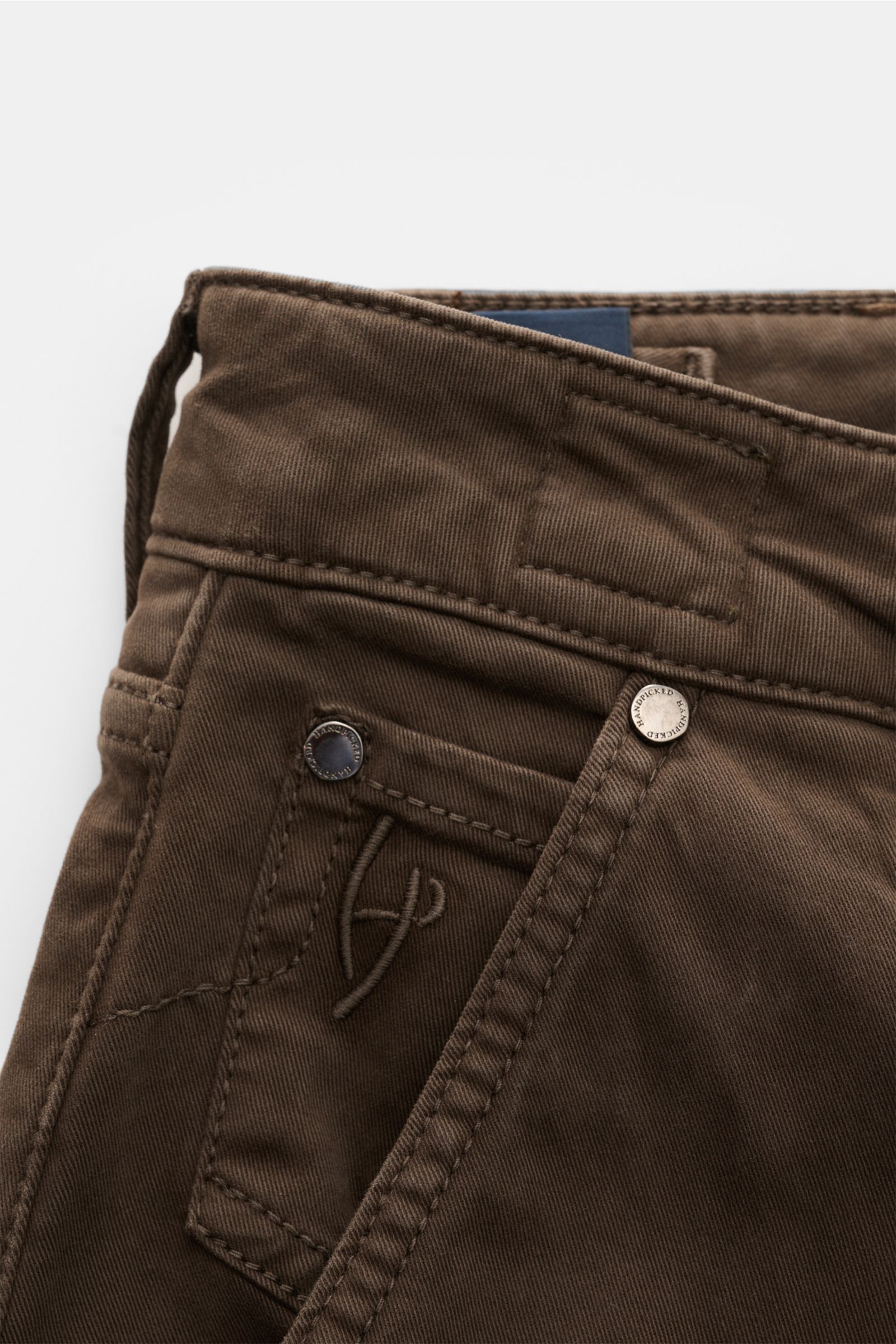 Nahaufnahme der HandPicked Chino 'Parma' dunkelbraun aus Twill Baumwolle, Slim Fit, Button Fly, französische Taschen, Münztasche mit Initial und Leather Patch.